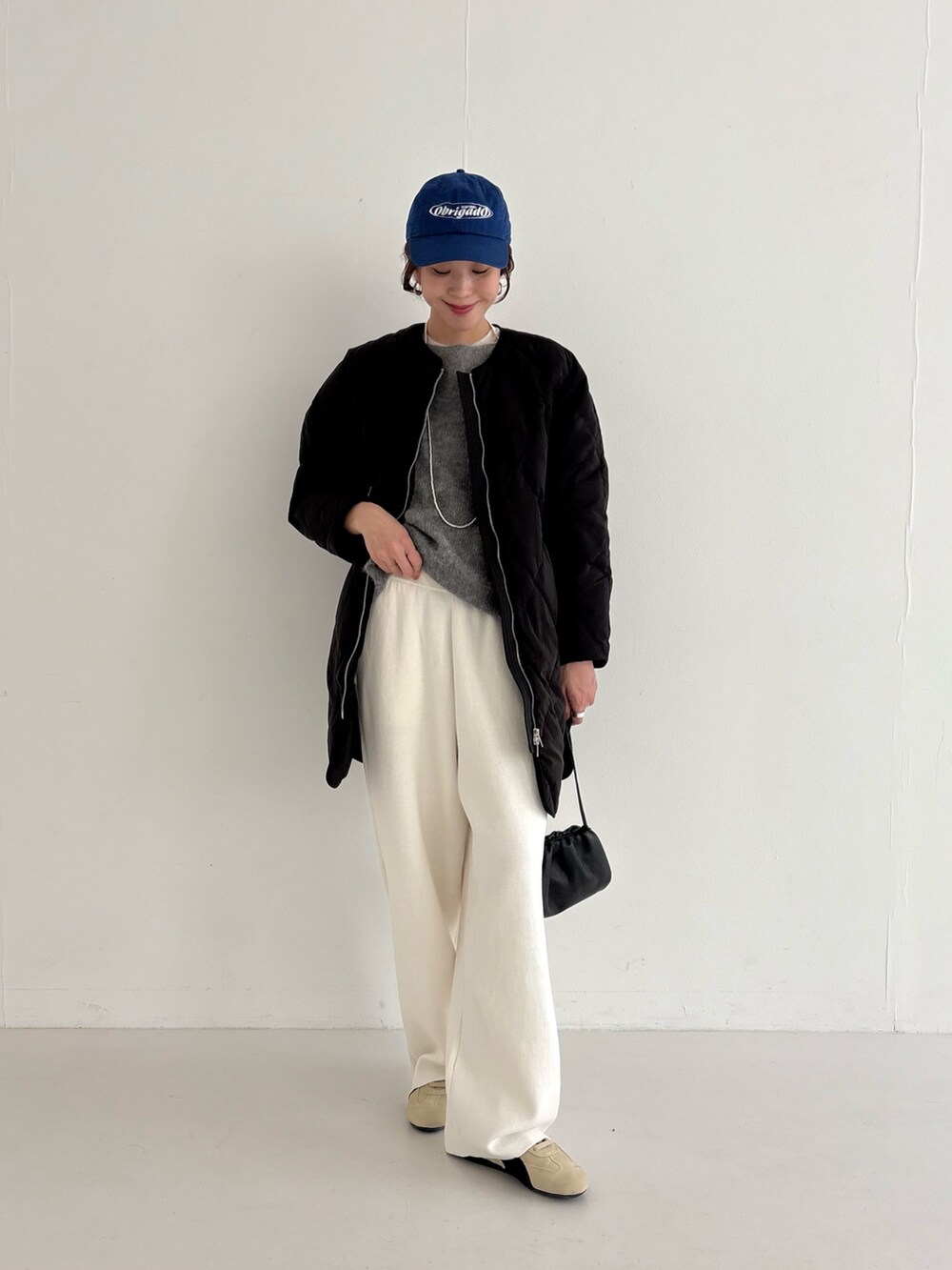 ベージュ系のスニーカー、ブラック系のダウンジャケット/コート、ピンク系のニット/セーターを着用したレディースの秋コーディネートの2枚目の写真