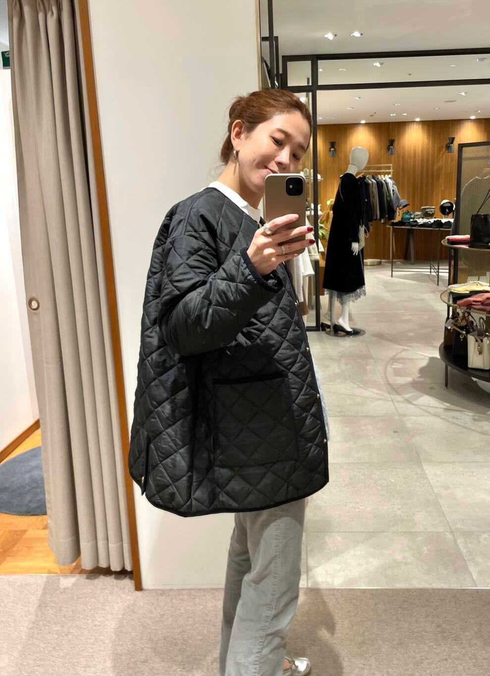 ブラック系のダウンジャケット/コート、ブラック系のショルダーバッグ、ホワイト系のTシャツ/カットソーを着用したレディースの冬コーディネートの2枚目の写真