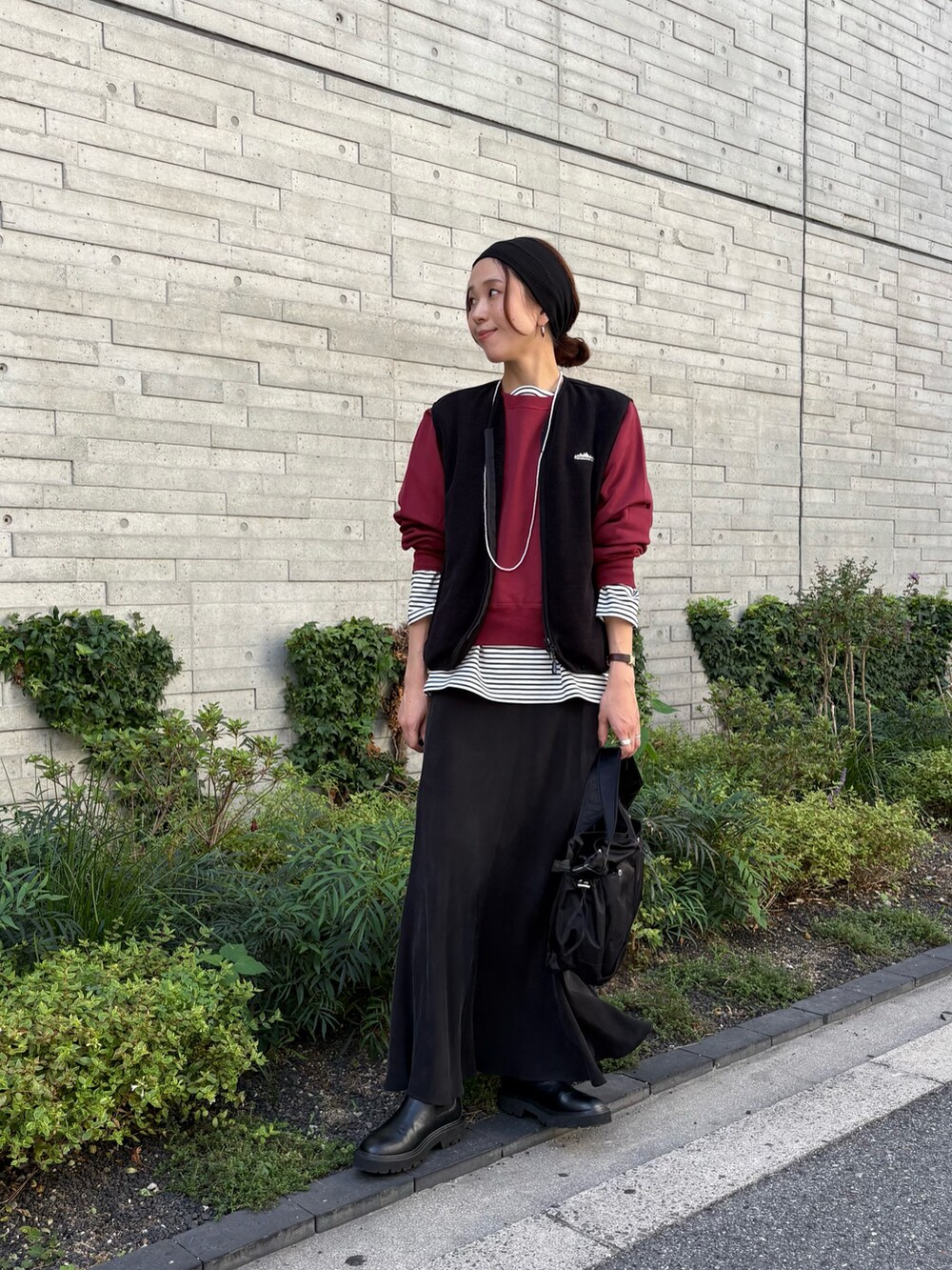 レッド系のスウェット、ブラック系のスカート、ブラック系のショルダーバッグを着用したレディースの秋コーディネートの5枚目の写真
