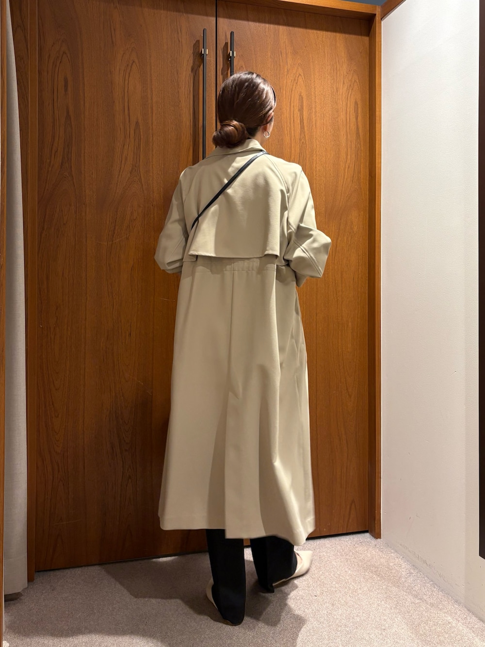 ベージュ系のトレンチコート、ブラック系のその他パンツ、ブラック系のその他アウターを着用したレディースの冬コーディネートの4枚目の写真