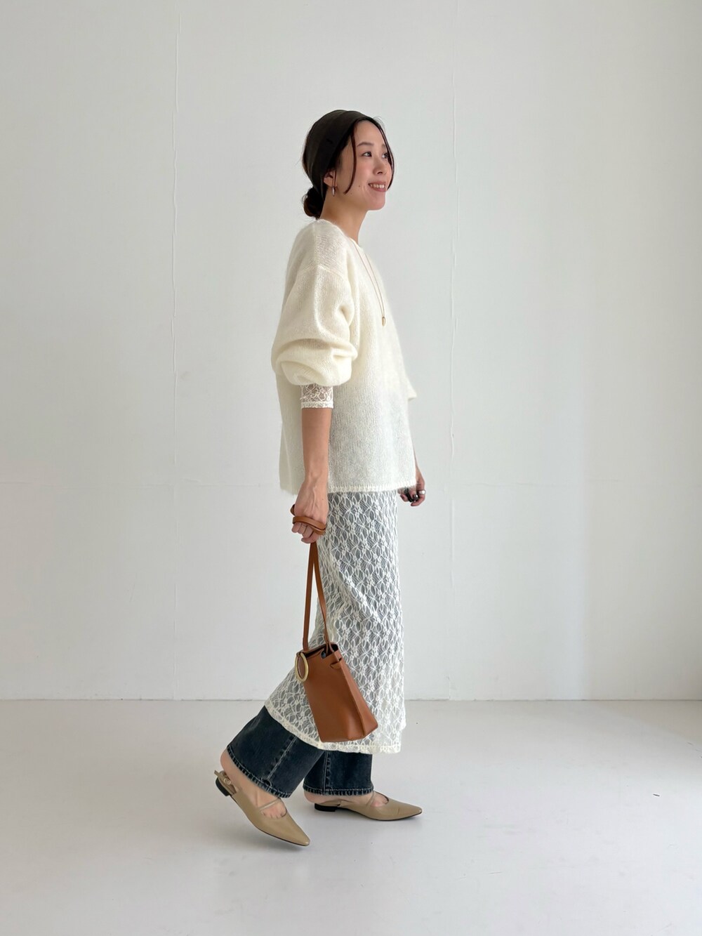 ホワイト系のニット/セーター、ホワイト系のワンピース、ブラック系のデニムパンツを着用したレディースの秋コーディネートの2枚目の写真