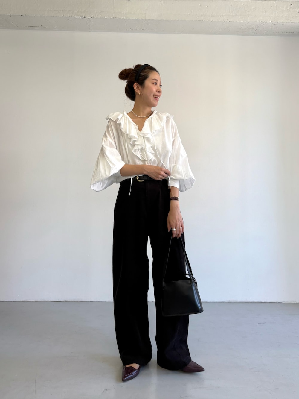 グレー系のその他パンツ、ホワイト系のシャツ/ブラウス、ブラック系のハンドバッグを着用したレディースの秋コーディネートの2枚目の写真