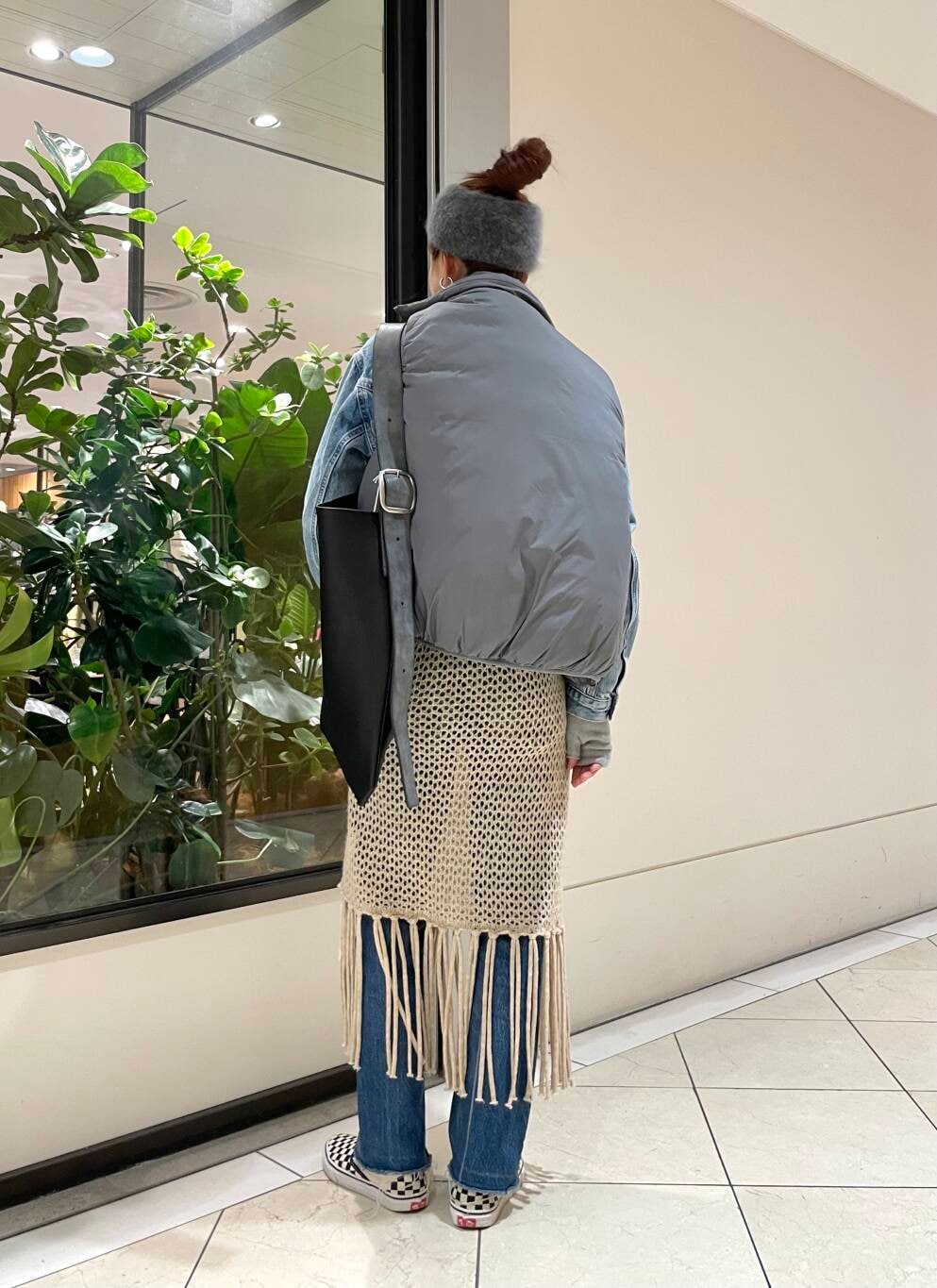 ベージュ系のスカート、ホワイト系のTシャツ/カットソー、グレー系のダウンベストを着用したレディースの冬コーディネートの4枚目の写真