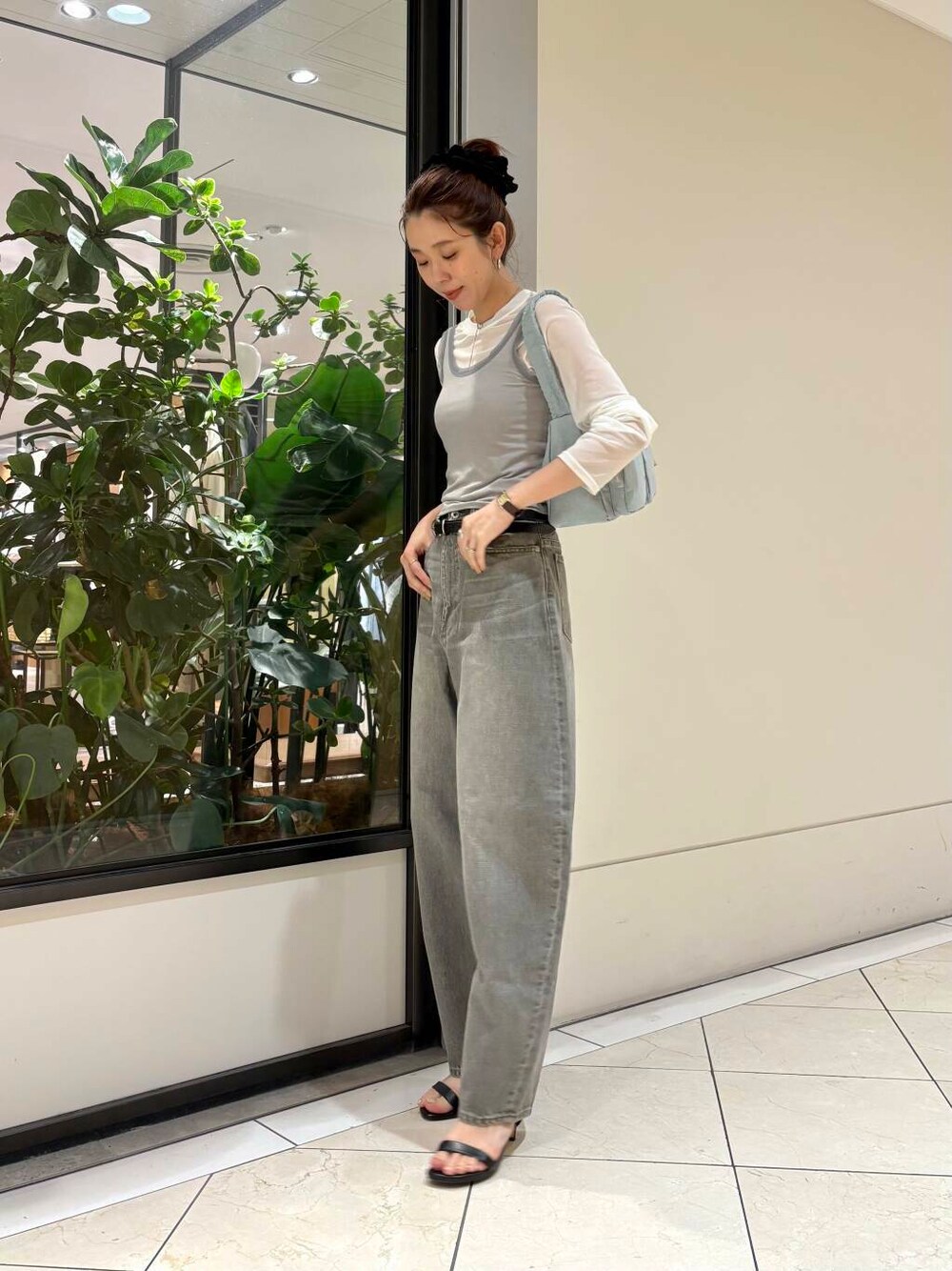 グリーン系のデニムパンツ、グリーン系のショルダーバッグ、グレー系のTシャツ/カットソーを着用したレディースの夏コーディネートの2枚目の写真