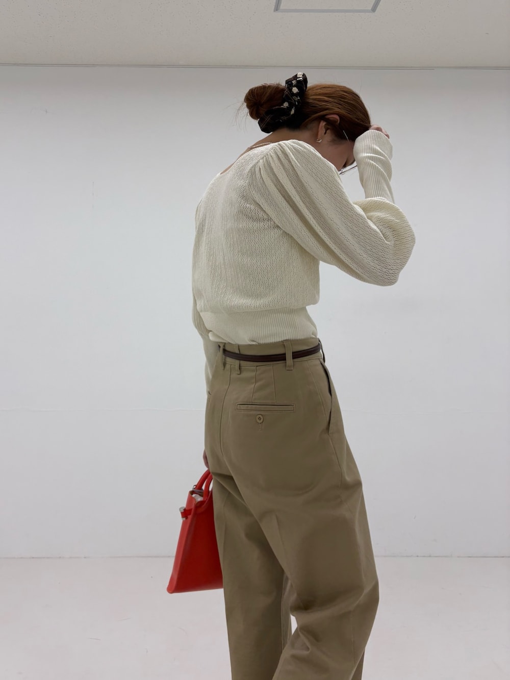 ホワイト系のニット/セーター、ベージュ系のその他パンツ、ブラック系のローファーを着用したレディースの夏コーディネートの8枚目の写真