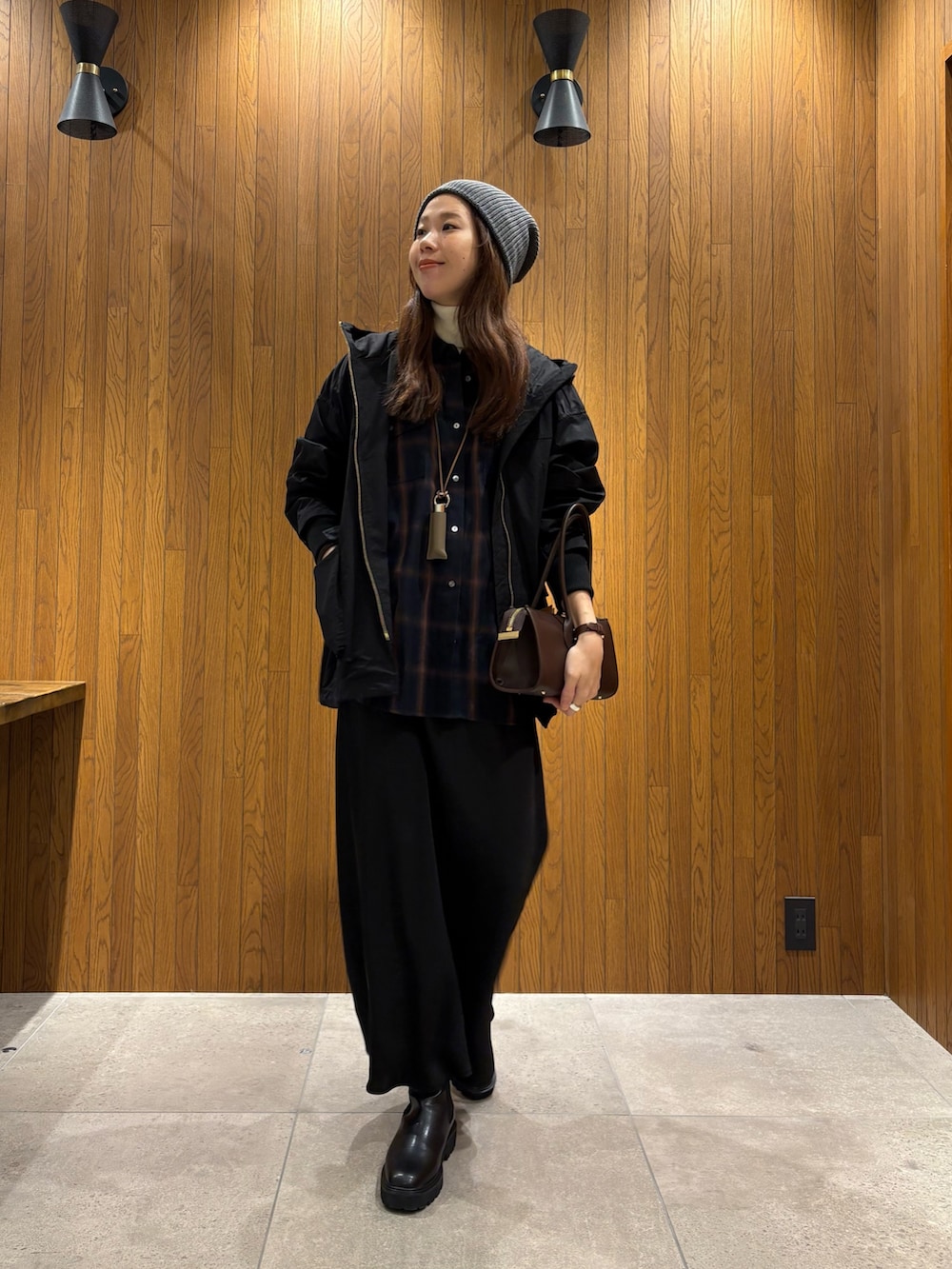 ブラック系のマウンテンパーカー、ブルー系のシャツ/ブラウス、ブラウン系のショルダーバッグを着用したレディースの冬コーディネートの4枚目の写真