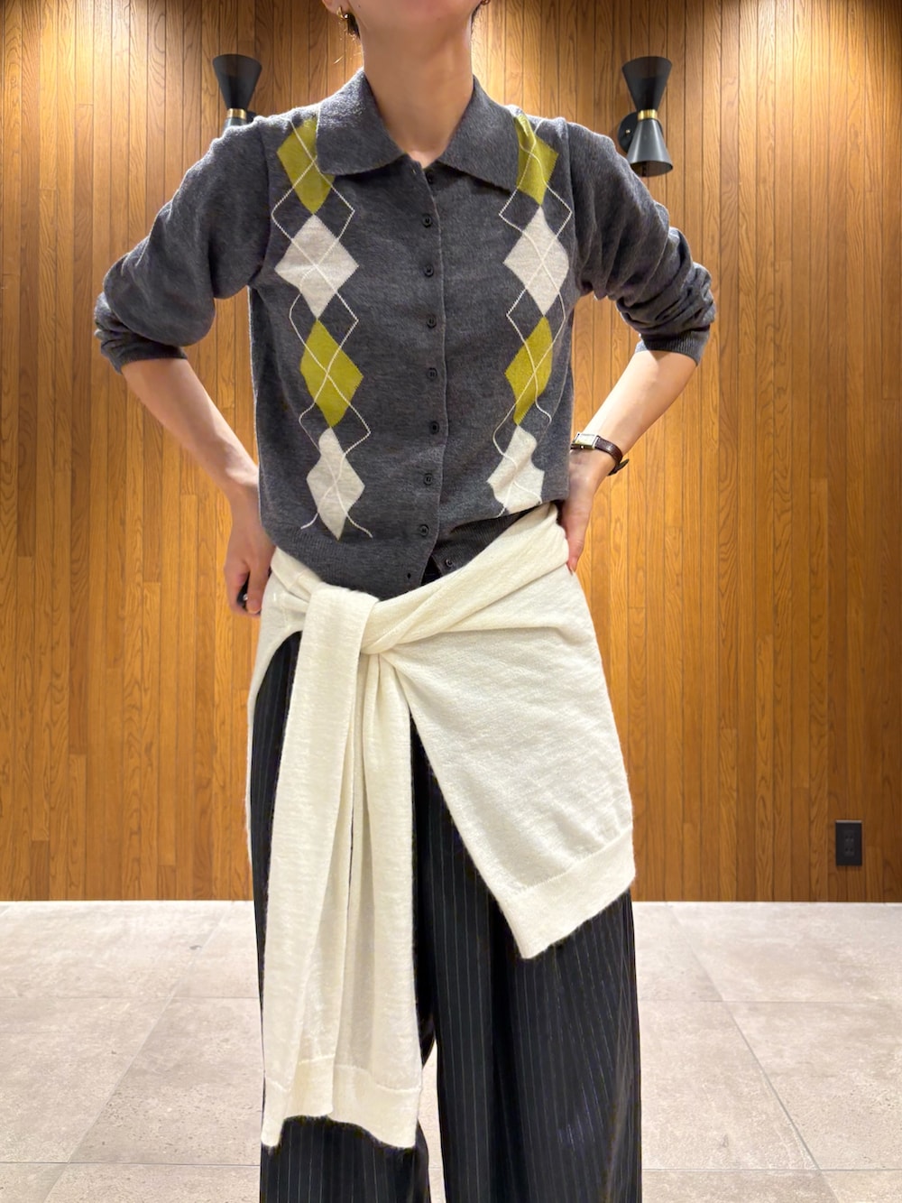 ホワイト系のスニーカー、ベージュ系のその他アウター、グレー系のニット/セーターを着用したレディースの秋コーディネートの7枚目の写真