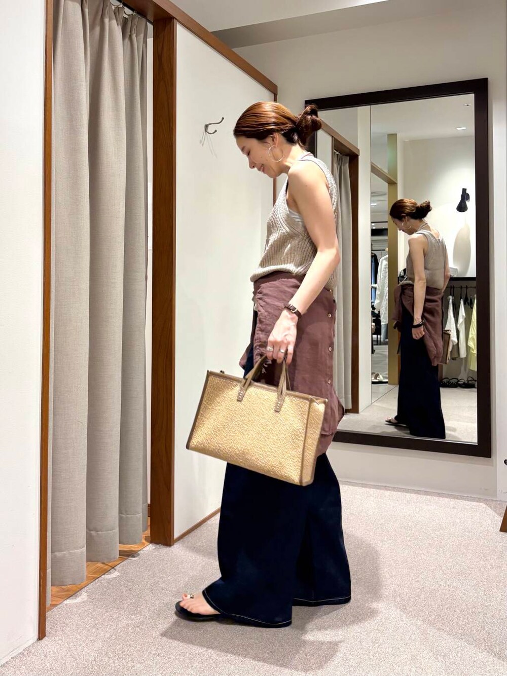 ブルー系のデニムパンツ、イエロー系のニット/セーター、ブラウン系のシャツ/ブラウスを着用したレディースの夏コーディネートの2枚目の写真