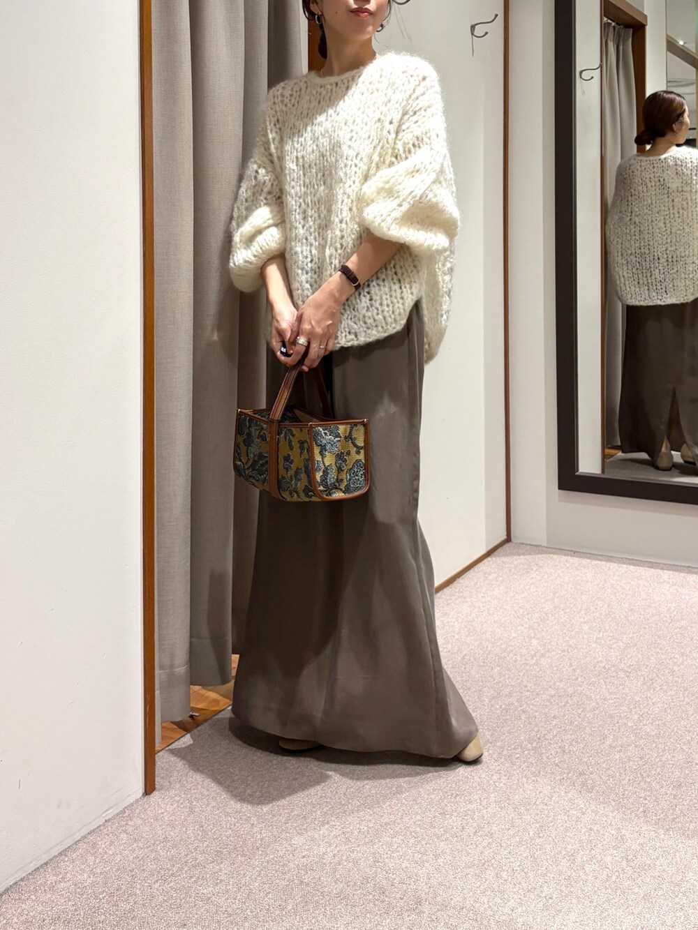 ホワイト系のニット/セーター、ブラック系のローファー、グリーン系のスカートを着用したレディースの秋コーディネートの5枚目の写真