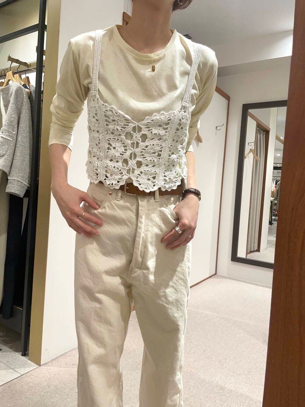 イエロー系のTシャツ/カットソー、グリーン系のトレンチコート、ホワイト系のニット/セーターを着用したレディースの春コーディネートの6枚目の写真