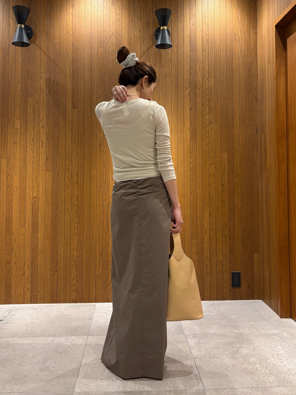 グレー系のスカート、ホワイト系のTシャツ/カットソー、ベージュ系のハンドバッグを着用したレディースの春コーディネートの8枚目の写真