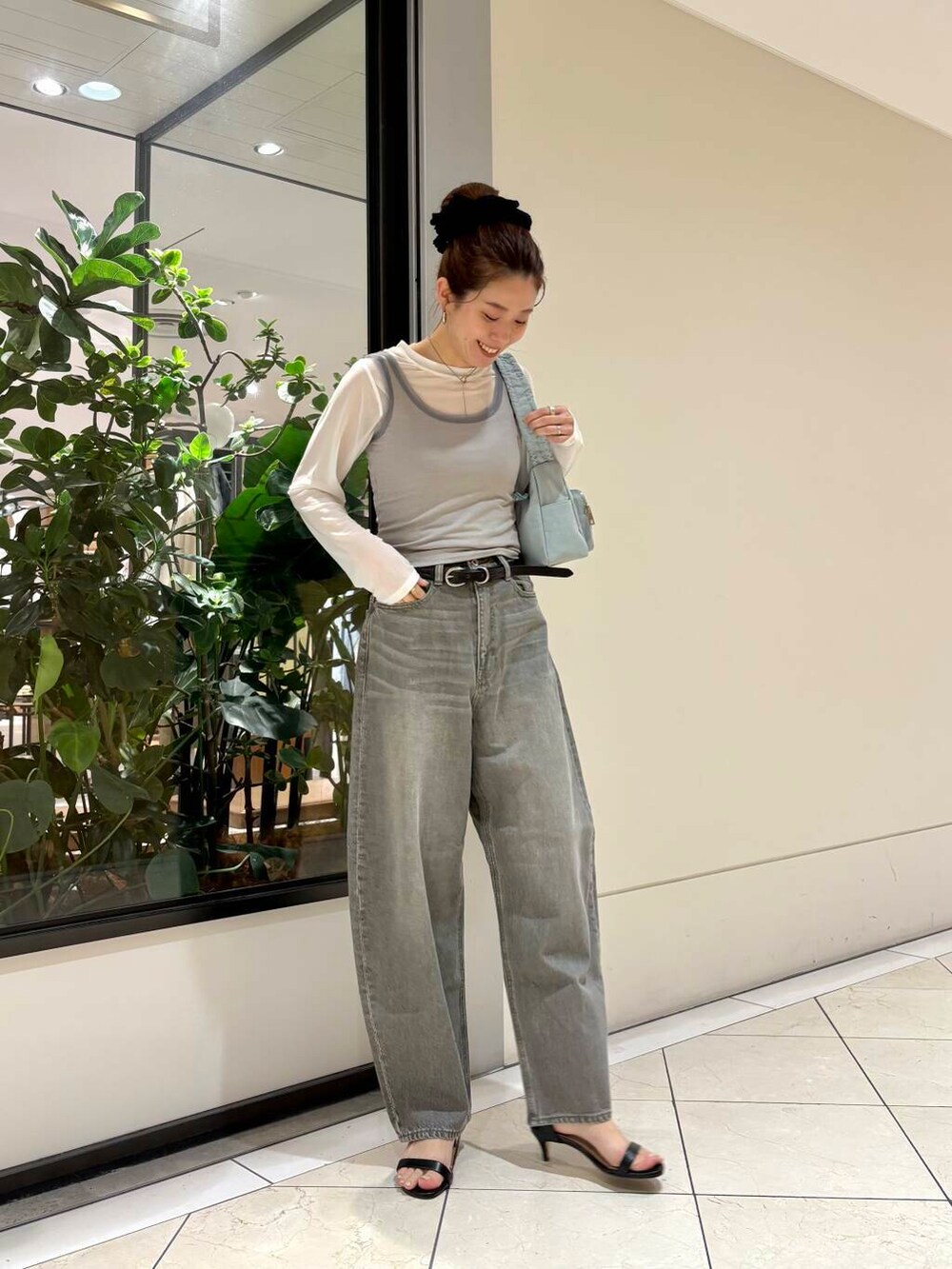 グリーン系のデニムパンツ、グリーン系のショルダーバッグ、グレー系のTシャツ/カットソーを着用したレディースの夏コーディネートの4枚目の写真