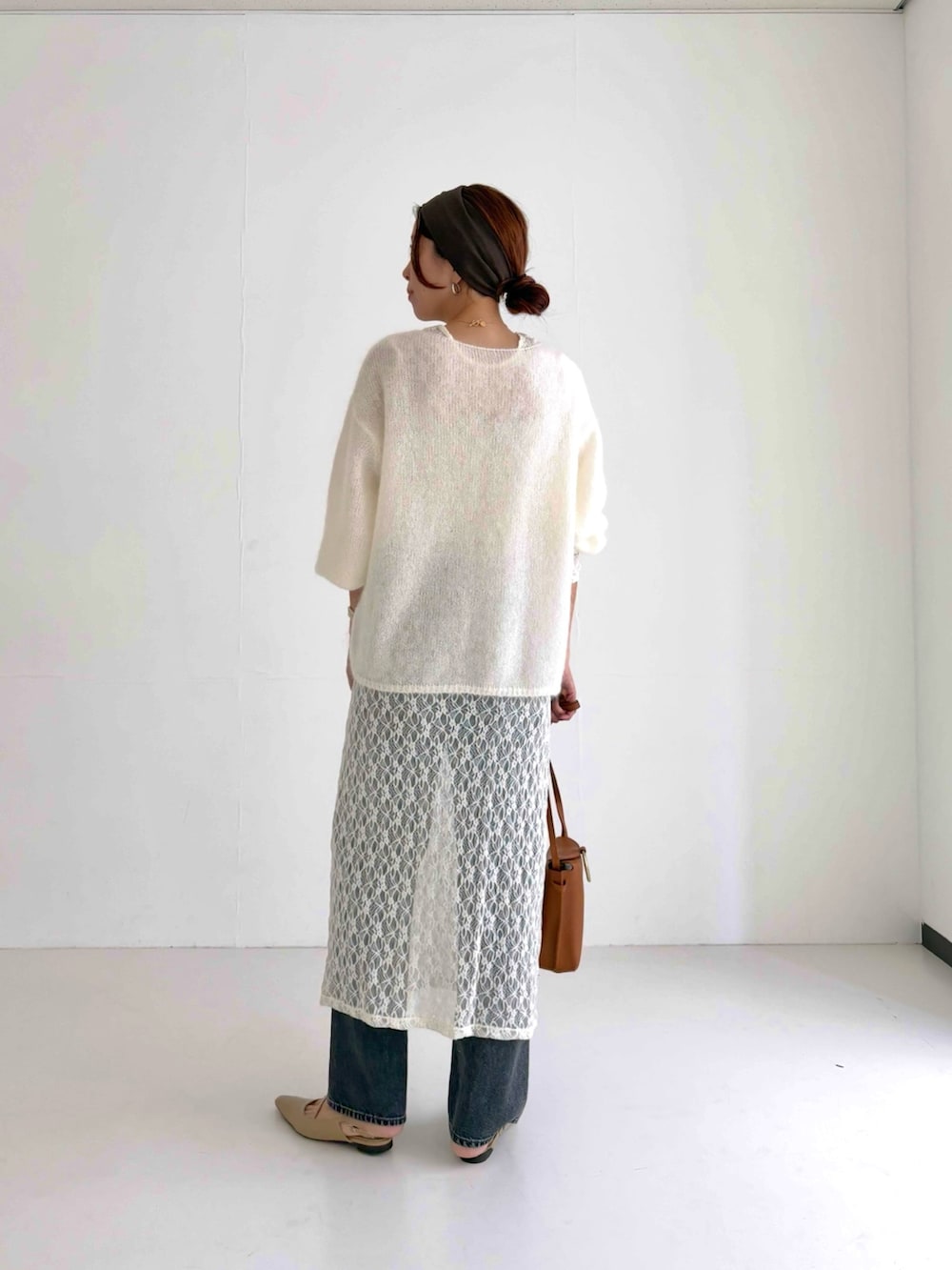 ホワイト系のニット/セーター、ホワイト系のワンピース、ブラック系のデニムパンツを着用したレディースの秋コーディネートの3枚目の写真