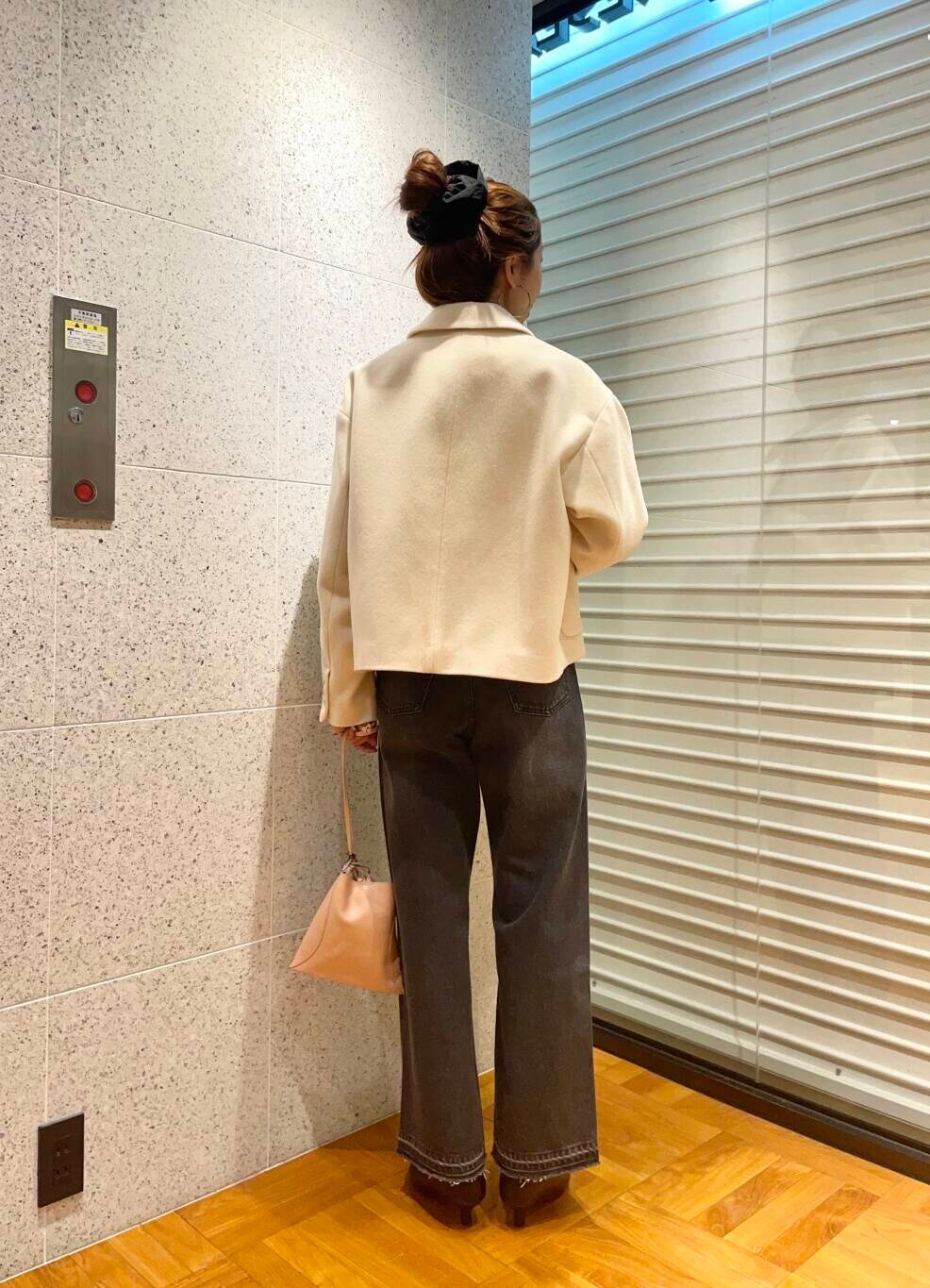 ブラック系のデニムパンツ、ブラウン系のニット/セーター、ブラック系のブーツを着用したレディースの冬コーディネートの5枚目の写真