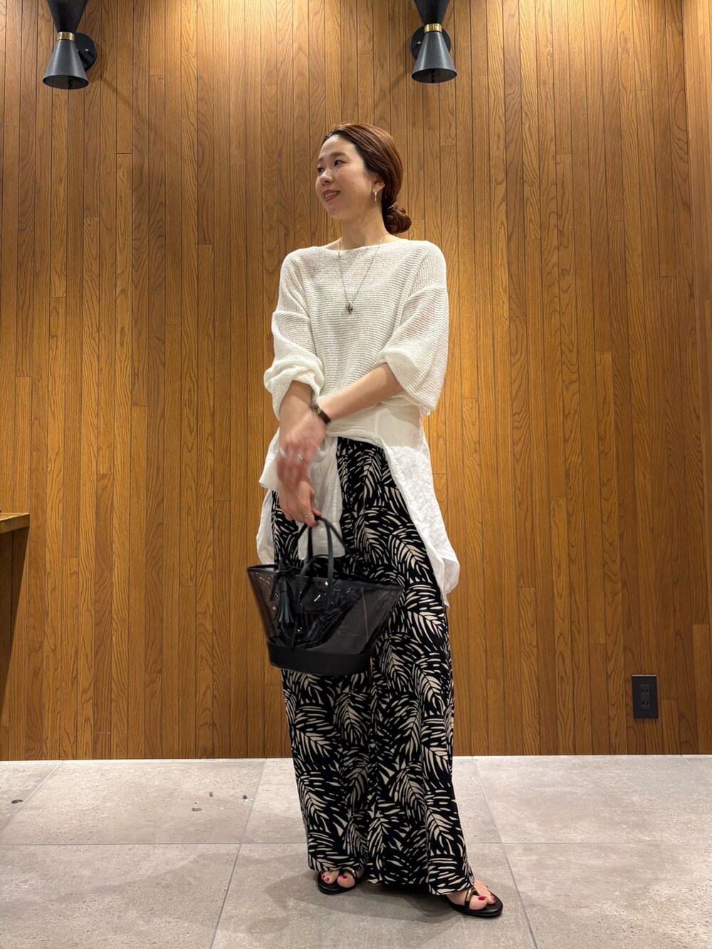 ホワイト系のニット/セーター、ブラック系のその他パンツ、ブラック系のかごバッグを着用したレディースの春コーディネートの4枚目の写真