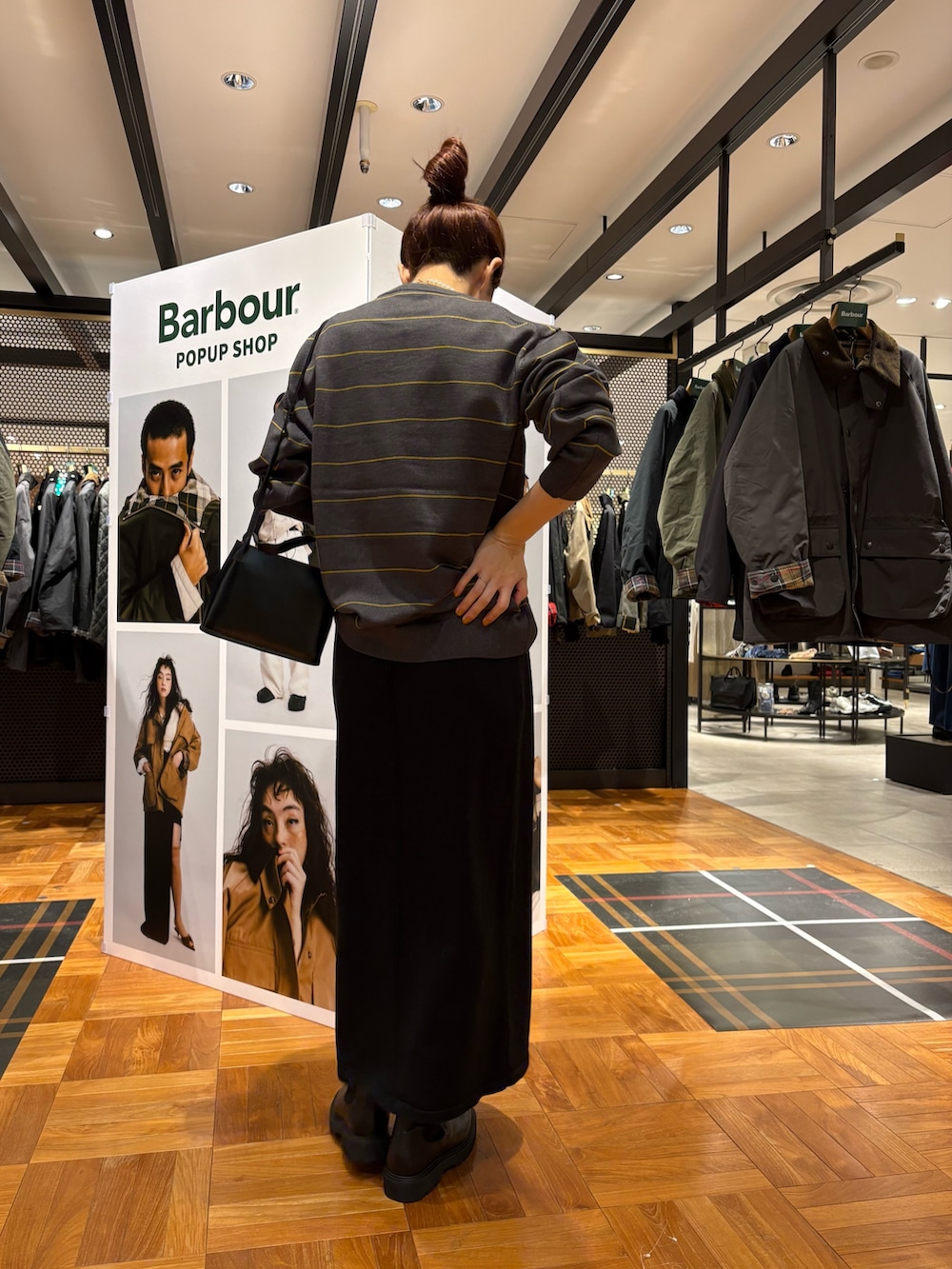 ブラック系のブーツ、ブラック系のショルダーバッグ、ブラック系のスカートを着用したレディースの秋コーディネートの4枚目の写真