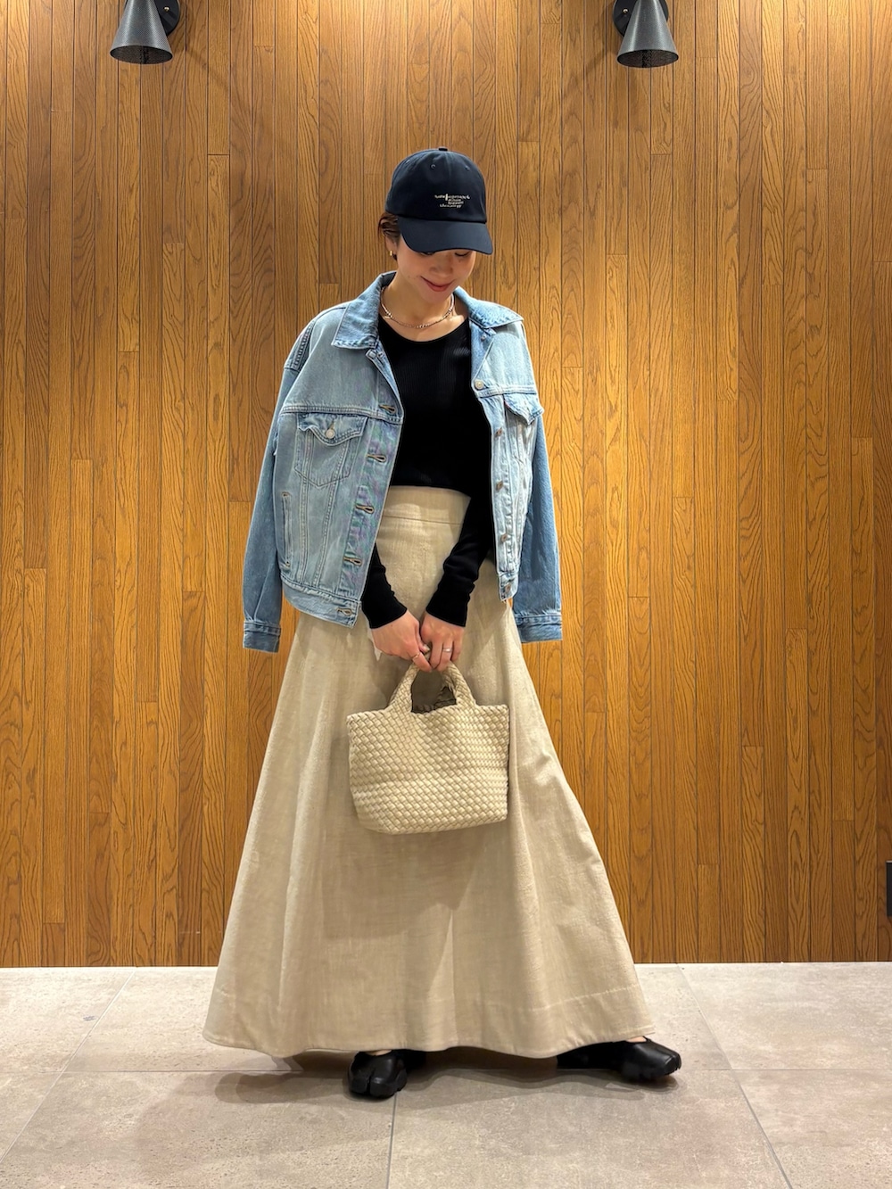 ホワイト系のトートバッグ、ブラック系のTシャツ/カットソー、ブルー系のデニムジャケットを着用したレディースの春コーディネートの5枚目の写真