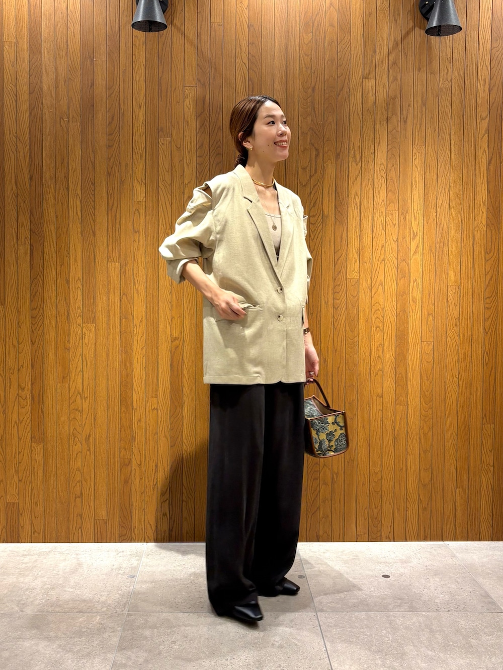 ホワイト系のその他アウター、ブラウン系のその他パンツ、ベージュ系のハンドバッグを着用したレディースの秋コーディネートの3枚目の写真