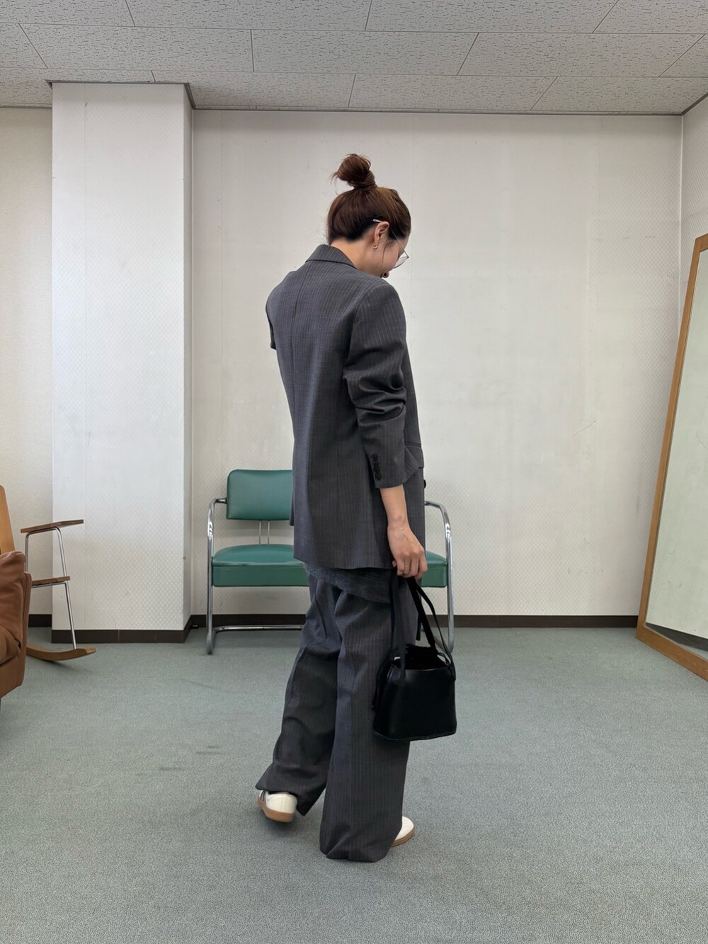 グレー系のその他パンツ、ホワイト系のスニーカー、ブラック系のハンドバッグを着用したレディースの秋コーディネートの3枚目の写真