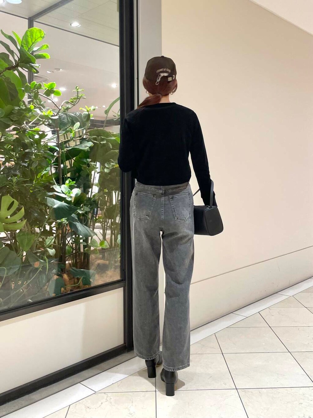 ブラック系のデニムパンツ、ブラック系のカーディガン/ボレロ、ホワイト系のTシャツ/カットソーを着用したレディースの秋コーディネートの4枚目の写真