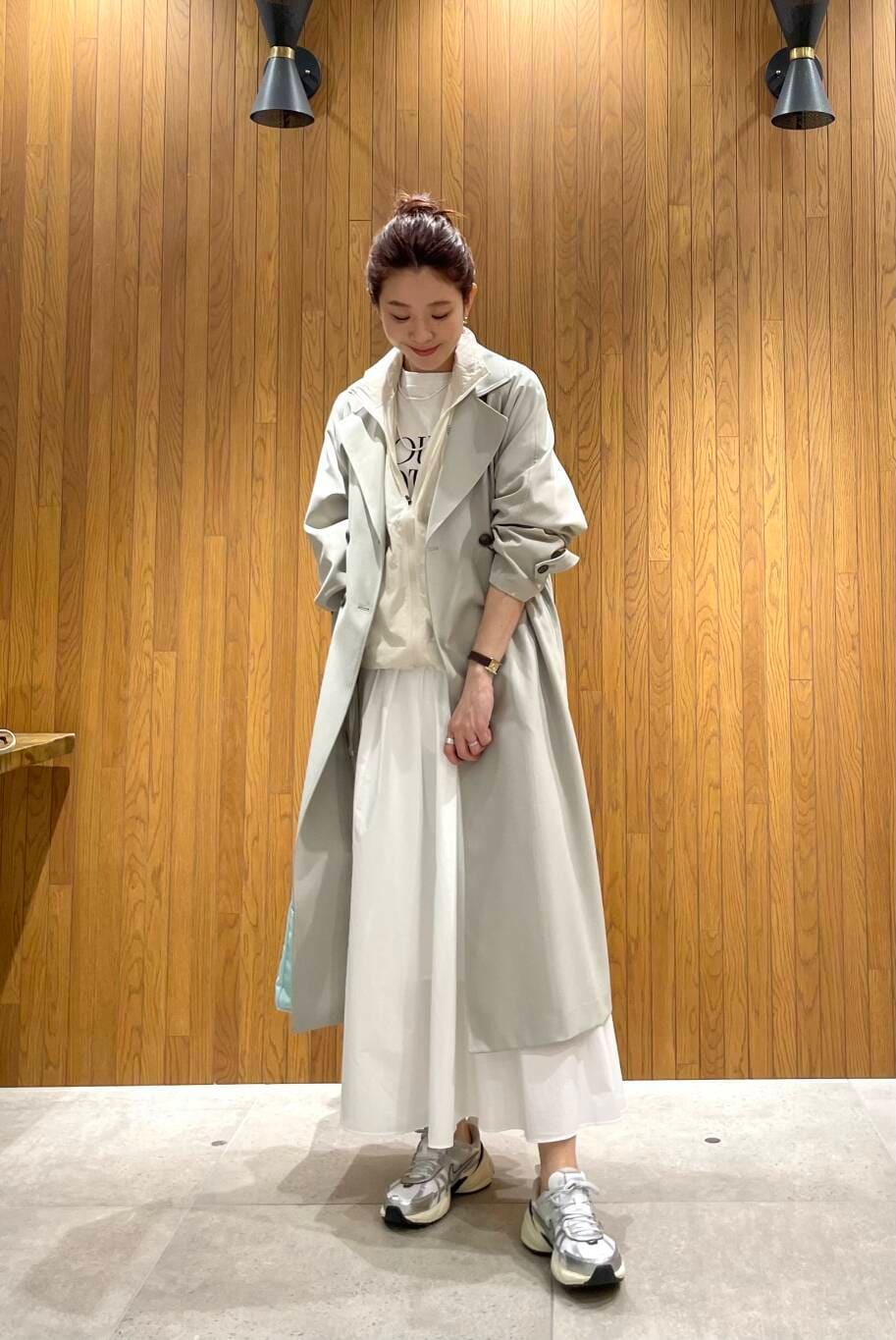 グリーン系のトレンチコート、その他のTシャツ/カットソー、ホワイト系のスカートを着用したレディースの春コーディネートの5枚目の写真