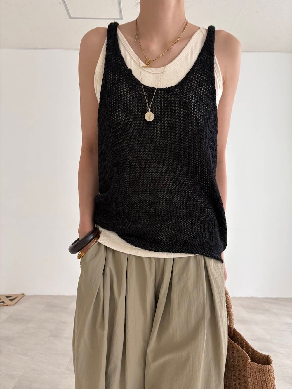 ベージュ系のその他パンツ、ホワイト系のキャミソール、ブラック系のニット/セーターを着用したレディースの夏コーディネートの5枚目の写真