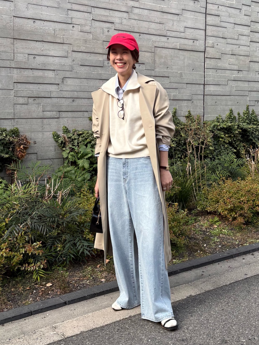 ベージュ系のトレンチコート、グレー系のデニムパンツ、ブラック系のショルダーバッグを着用したレディースの冬コーディネートの4枚目の写真