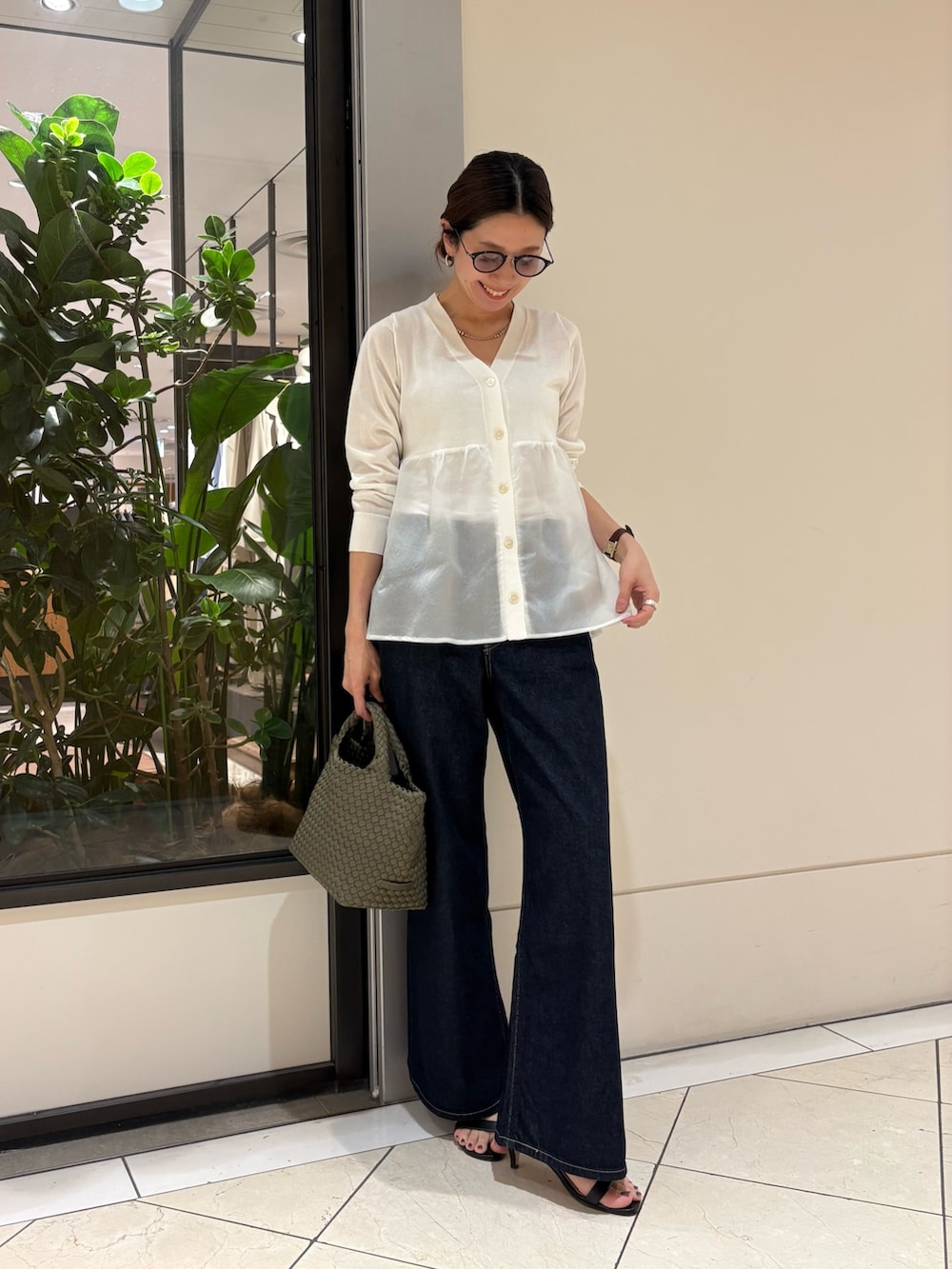 ホワイト系のカーディガン/ボレロ、ブルー系のデニムパンツ、グリーン系のトートバッグを着用したレディースの春コーディネートの4枚目の写真