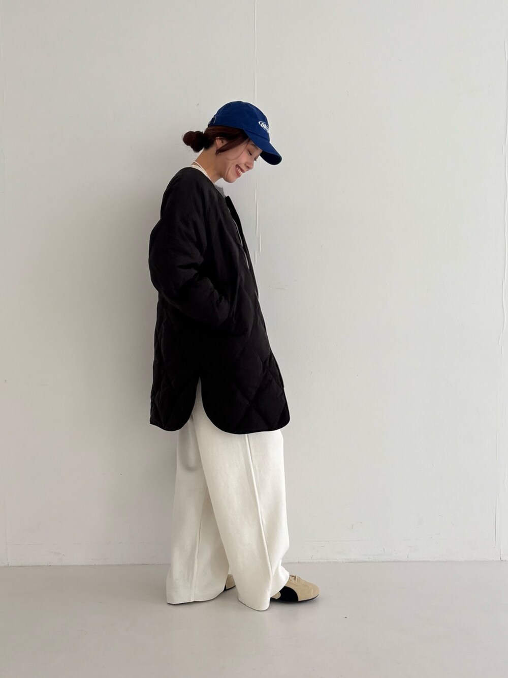 ベージュ系のスニーカー、ブラック系のダウンジャケット/コート、ピンク系のニット/セーターを着用したレディースの秋コーディネートの3枚目の写真