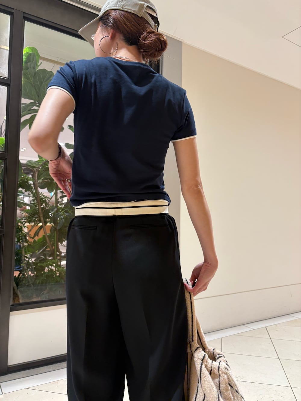 ブラック系のその他パンツ、グレー系のスニーカー、ホワイト系のハンドバッグを着用したレディースの夏コーディネートの7枚目の写真