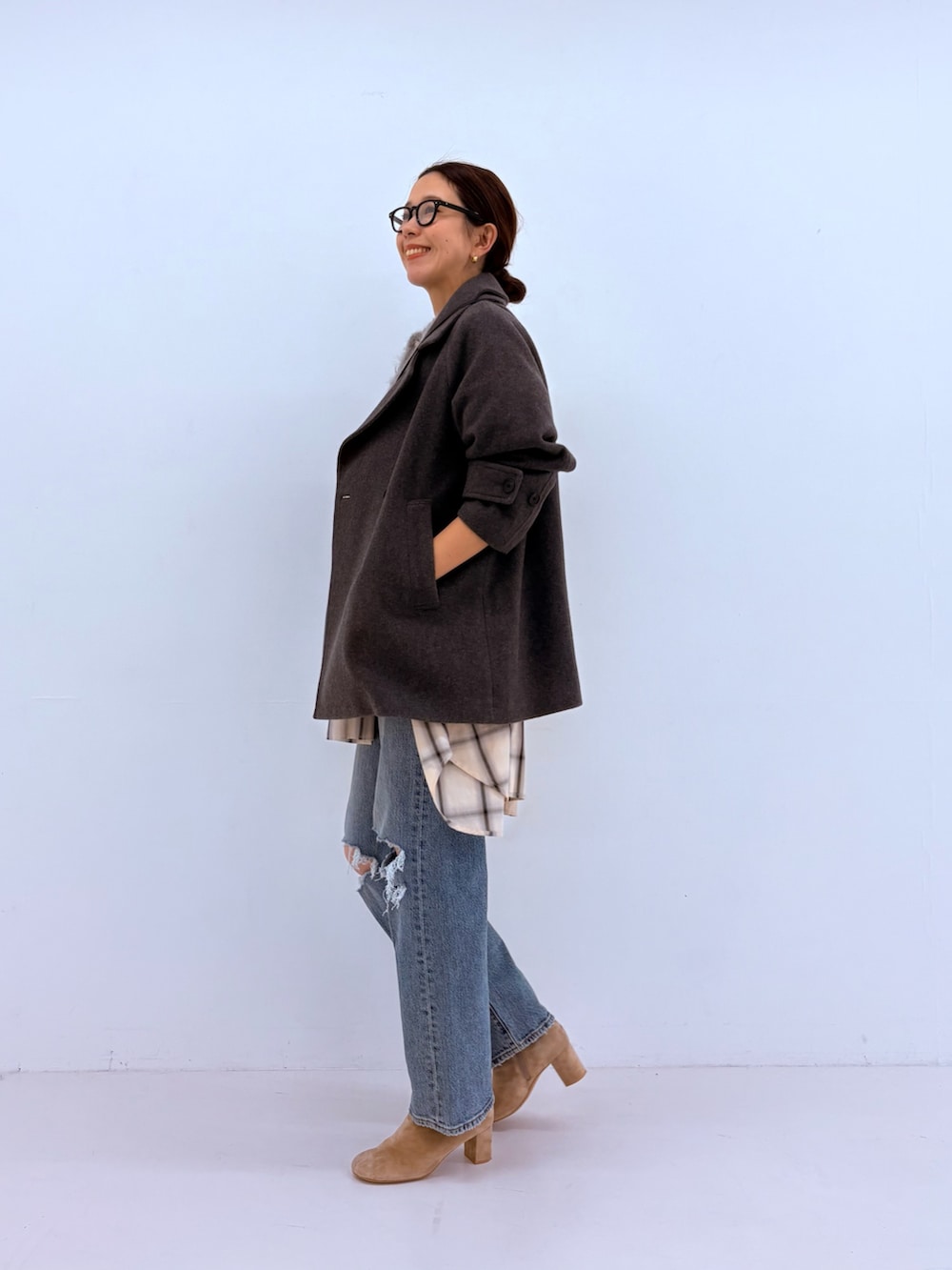 ブルー系のデニムパンツ、グリーン系のカーディガン/ボレロ、ホワイト系のピーコートを着用したレディースの秋コーディネートの4枚目の写真