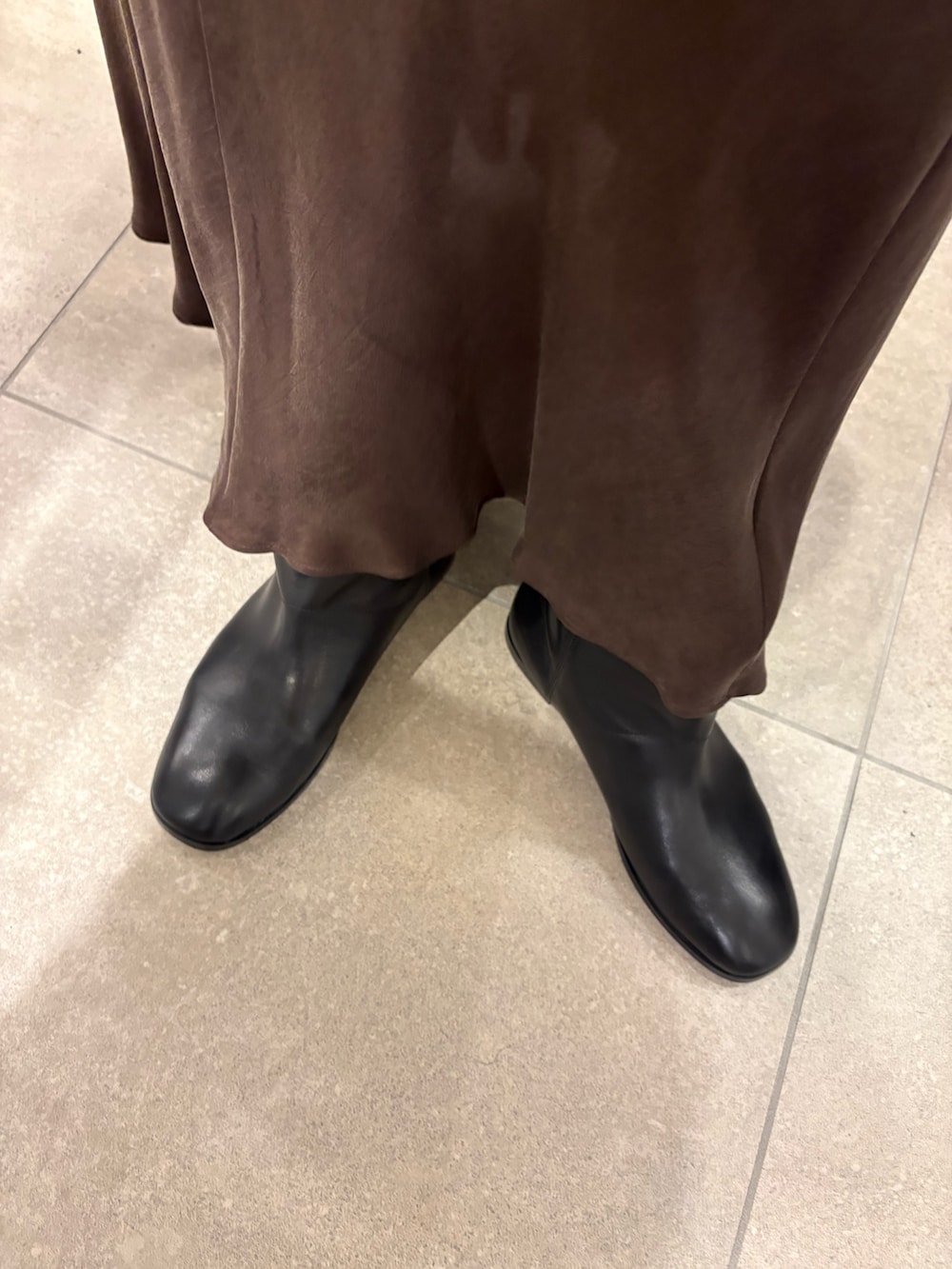 ホワイト系のシャツ/ブラウス、ブラウン系のスカート、ベージュ系のハンドバッグを着用したレディースの秋コーディネートの5枚目の写真