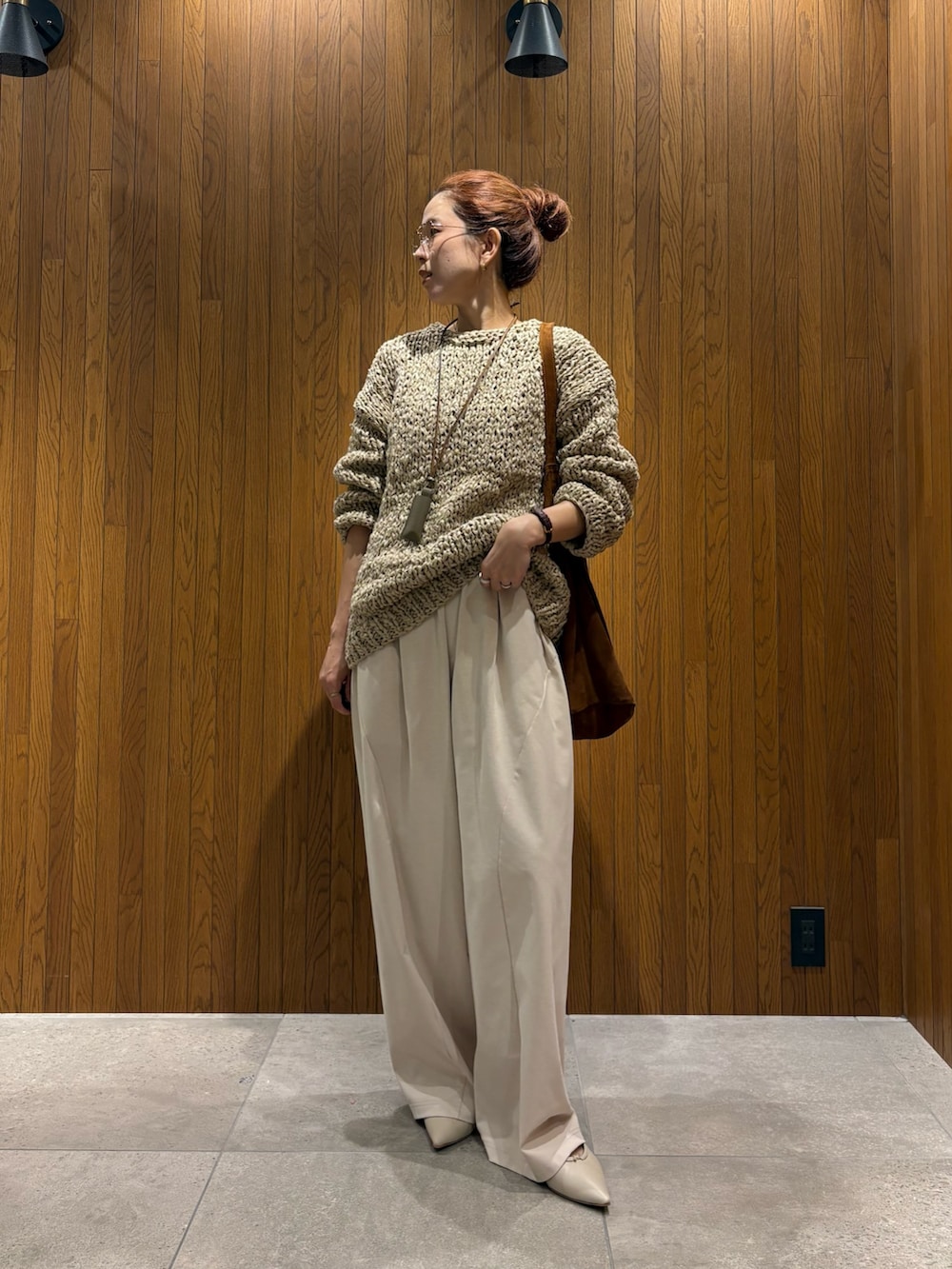 グレー系のニット/セーター、ホワイト系のその他パンツ、ブラウン系のトートバッグを着用したレディースの秋コーディネートの5枚目の写真