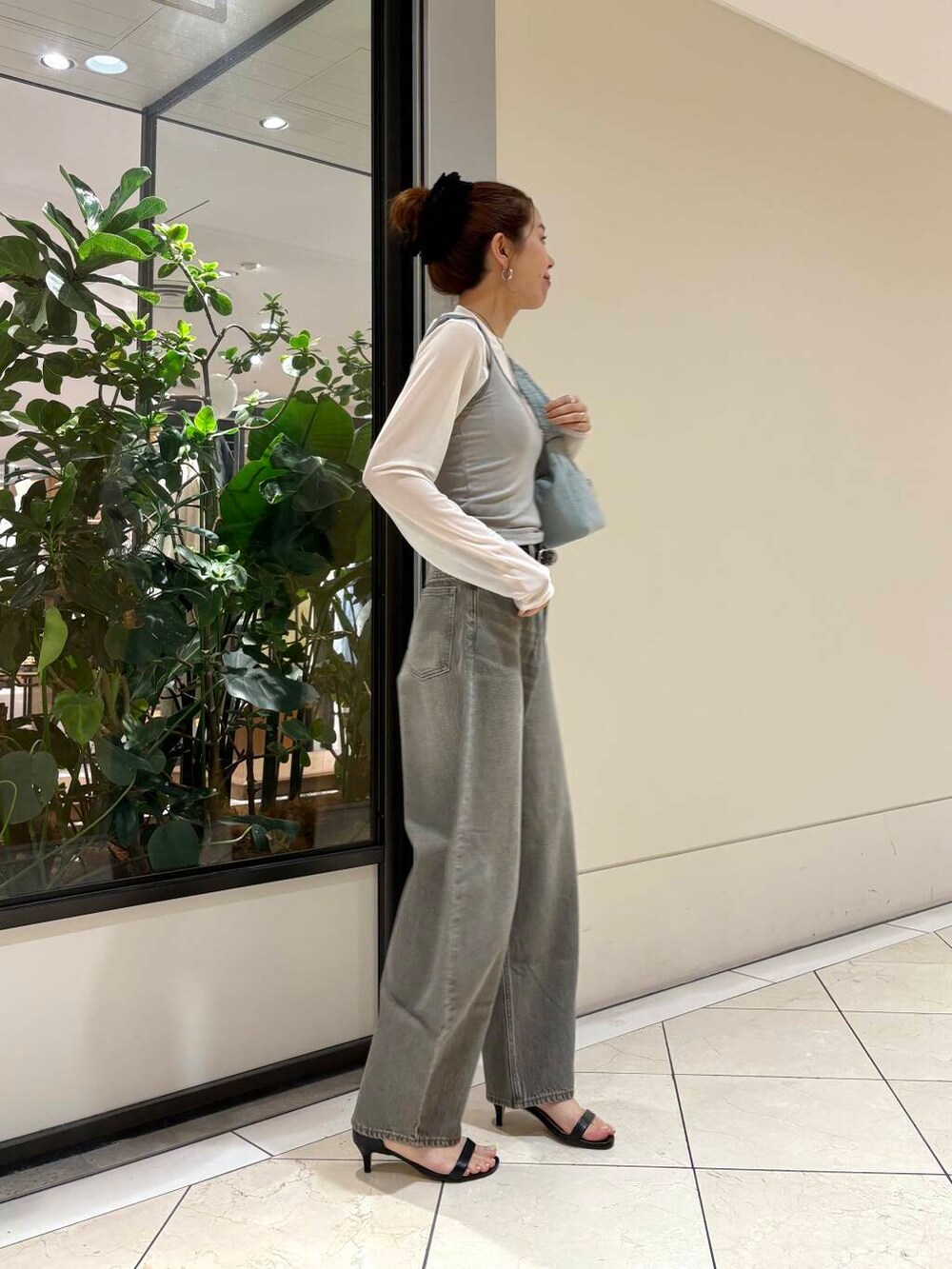 グリーン系のデニムパンツ、グリーン系のショルダーバッグ、グレー系のTシャツ/カットソーを着用したレディースの夏コーディネートの5枚目の写真