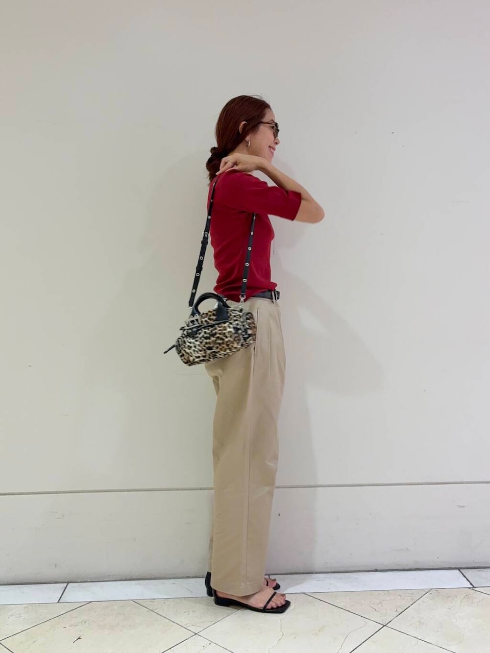 ベージュ系のチノパンツ、ブラック系のサンダル、レッド系のTシャツ/カットソーを着用したレディースの夏コーディネートの5枚目の写真