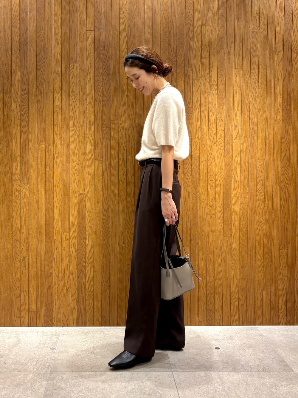 ホワイト系のニット/セーター、ブラウン系のその他パンツ、グレー系のハンドバッグを着用したレディースの秋コーディネートの2枚目の写真