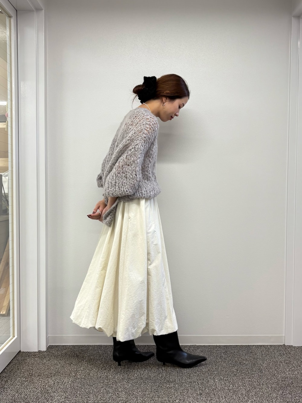 ホワイト系のスカート、ブラック系のブーツ、グレー系のニット/セーターを着用したレディースの秋コーディネートの6枚目の写真