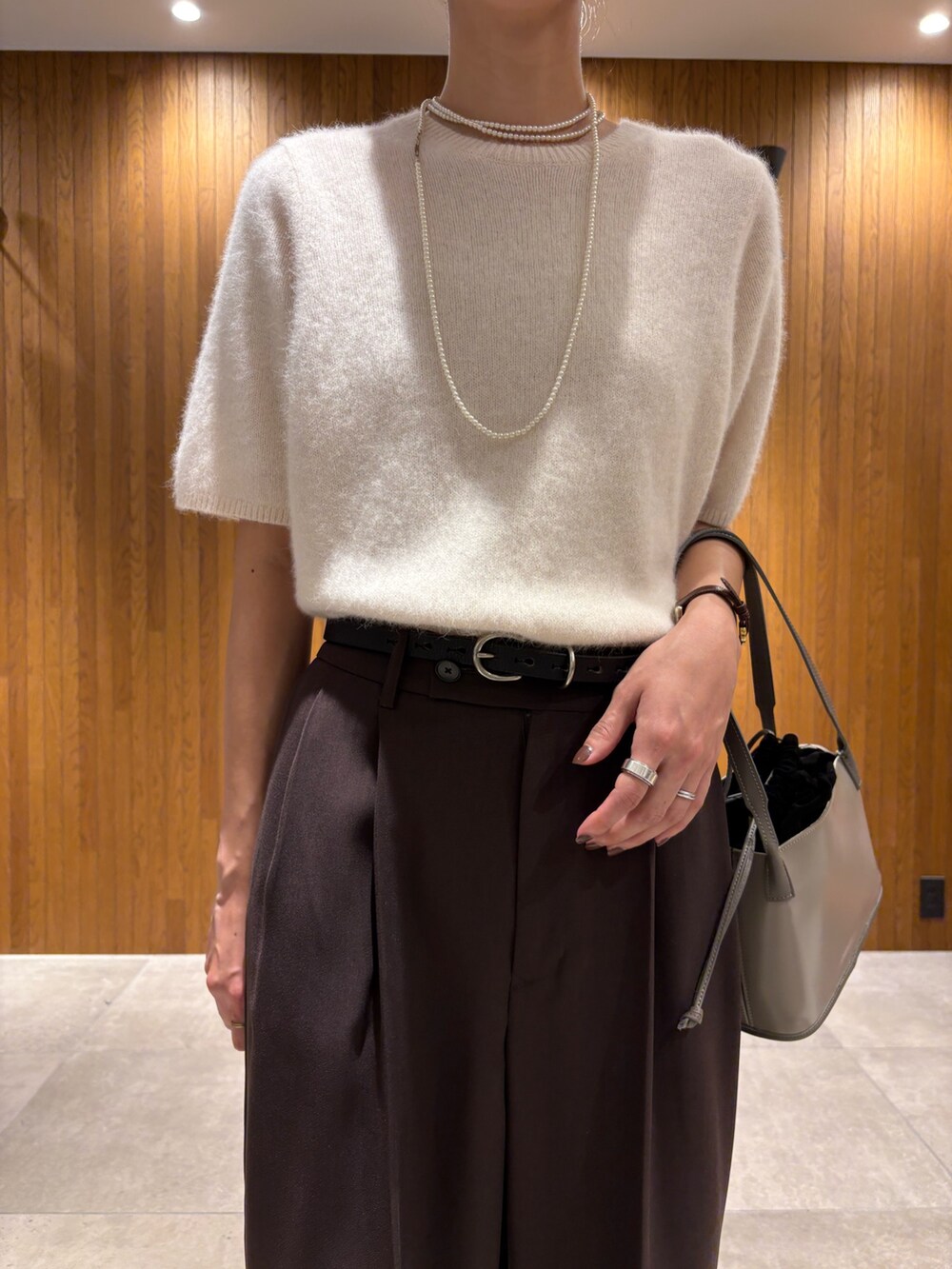 ホワイト系のニット/セーター、ブラウン系のその他パンツ、グレー系のハンドバッグを着用したレディースの秋コーディネートの7枚目の写真