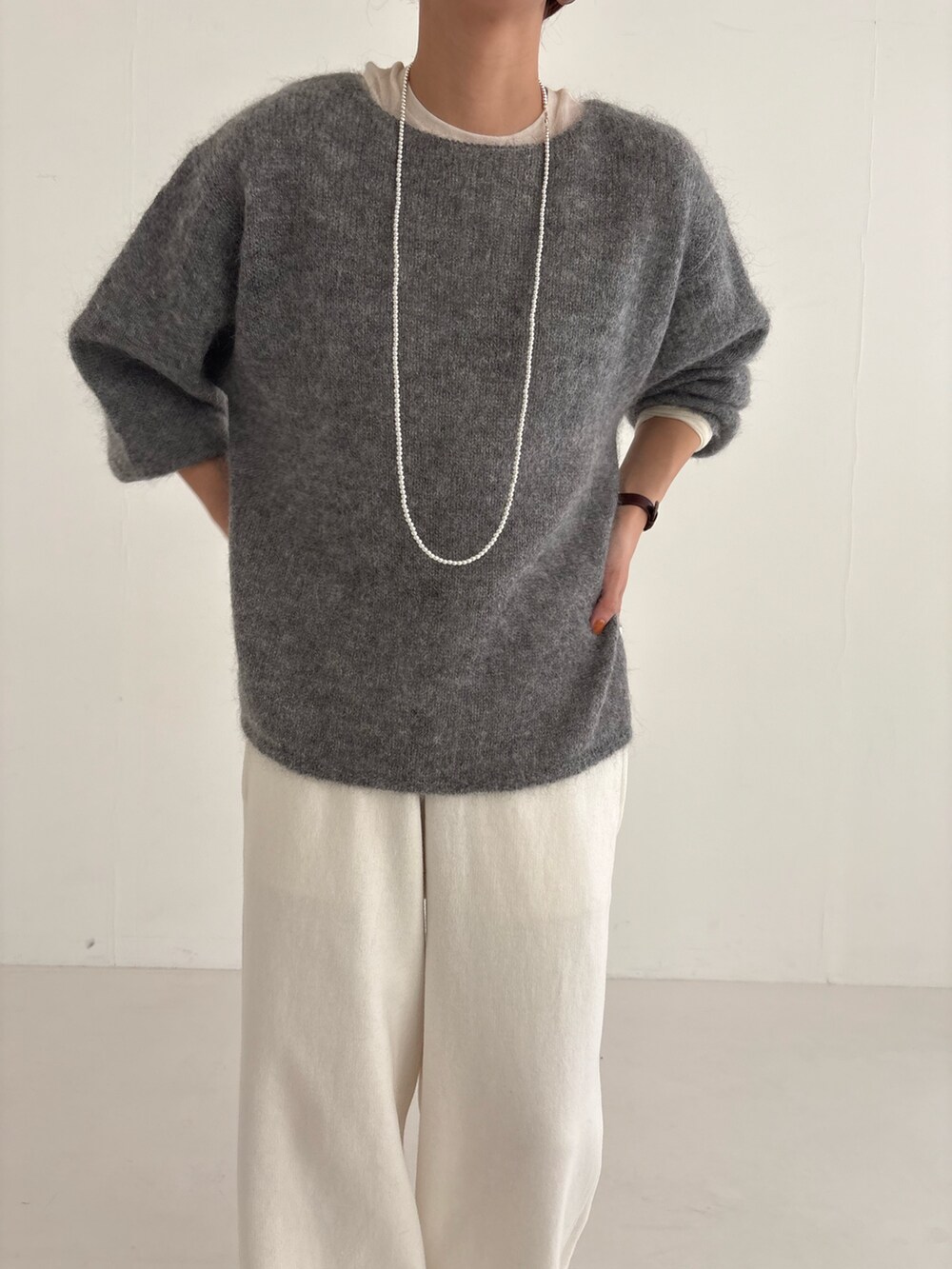 ベージュ系のスニーカー、ブラック系のダウンジャケット/コート、ピンク系のニット/セーターを着用したレディースの秋コーディネートの6枚目の写真