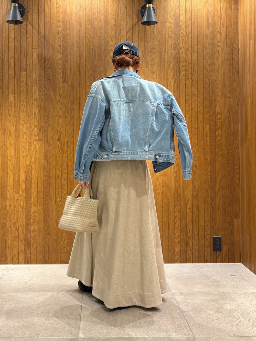 ホワイト系のトートバッグ、ブラック系のTシャツ/カットソー、ブルー系のデニムジャケットを着用したレディースの春コーディネートの3枚目の写真