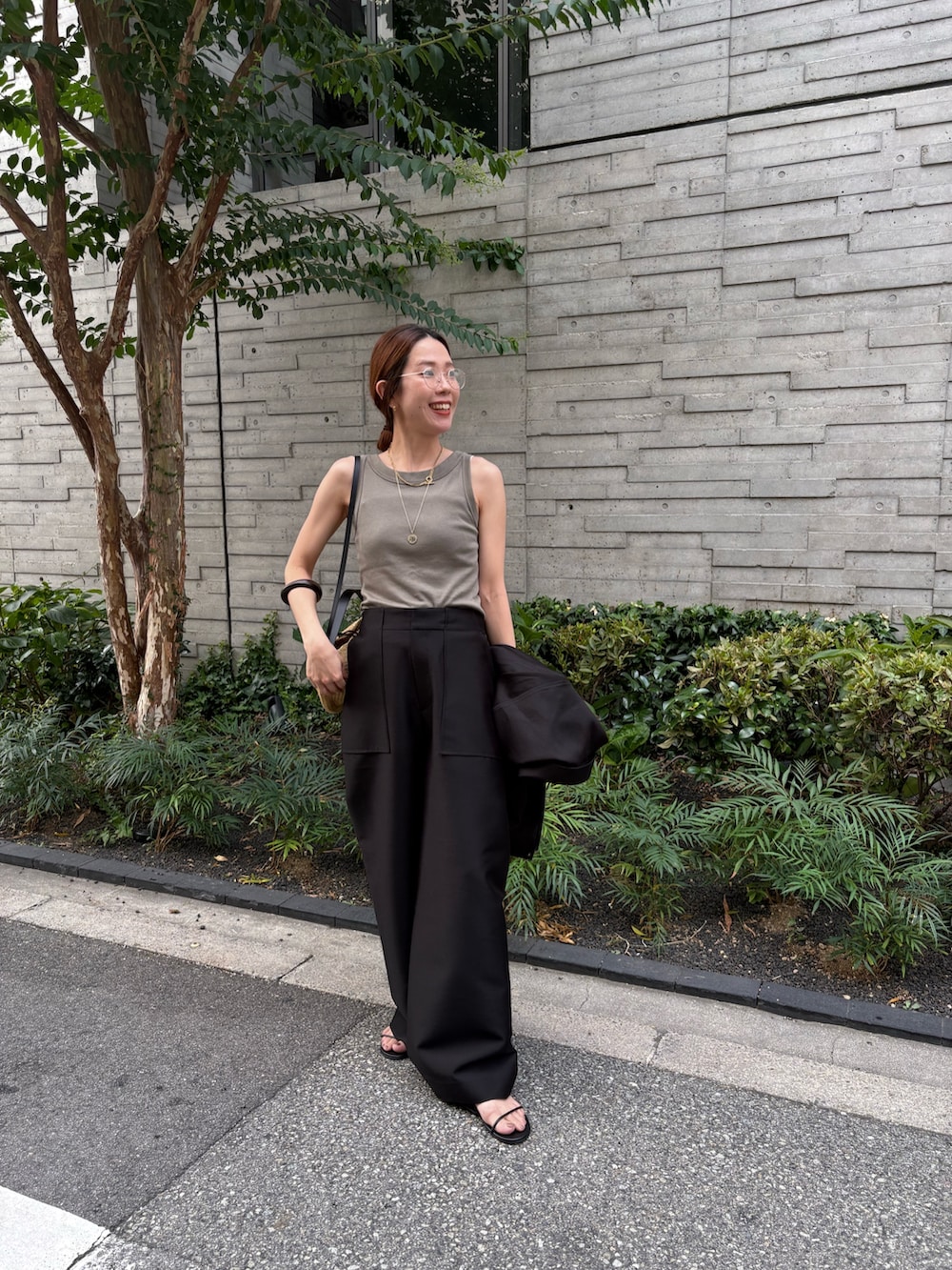 ブラック系のその他パンツ、グリーン系のタンクトップ、ブラック系のその他アウターを着用したレディースの秋コーディネートの4枚目の写真