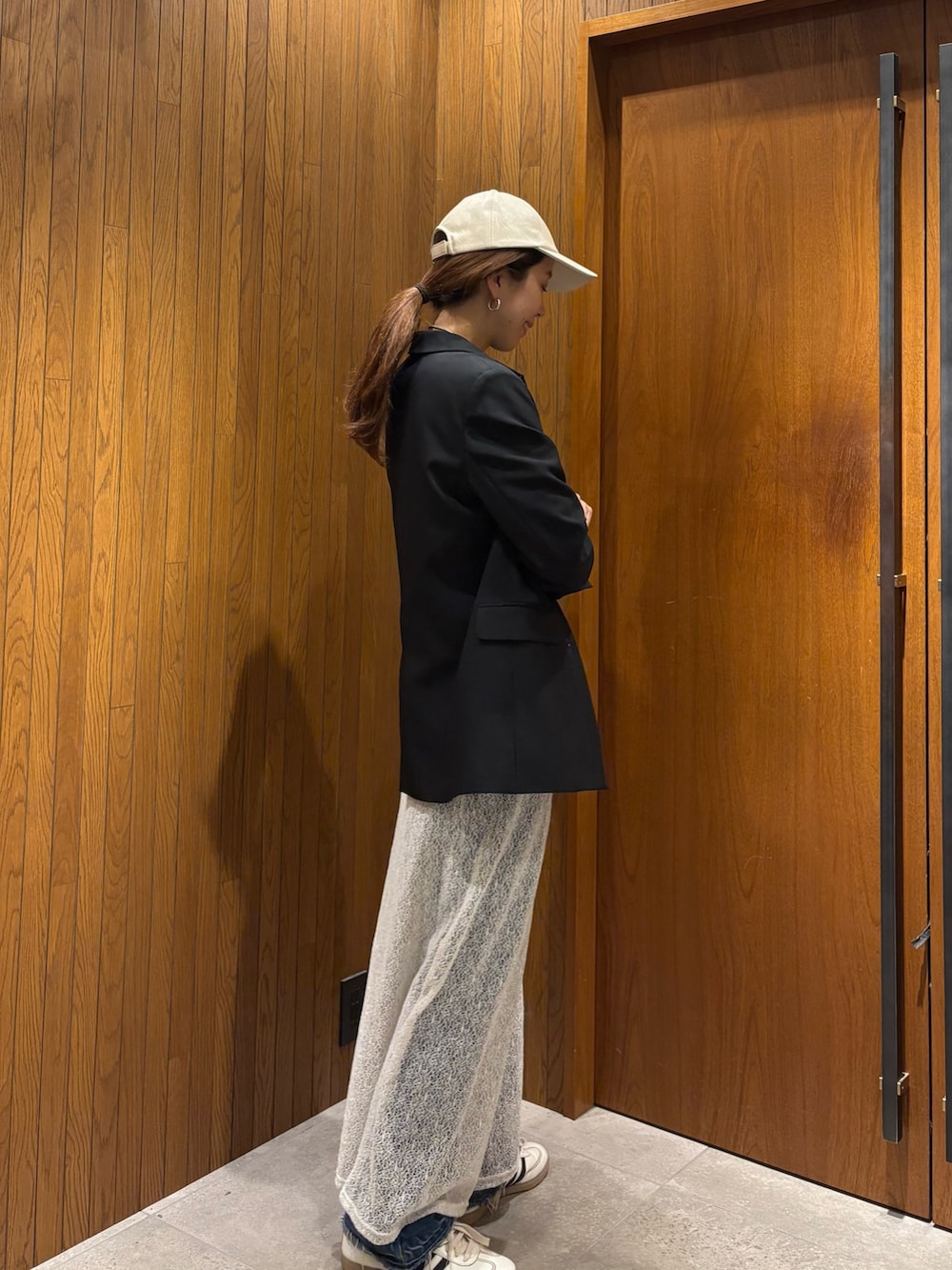 ホワイト系のスカート、ブラック系のその他アウター、ホワイト系のスニーカーを着用したレディースの冬コーディネートの2枚目の写真