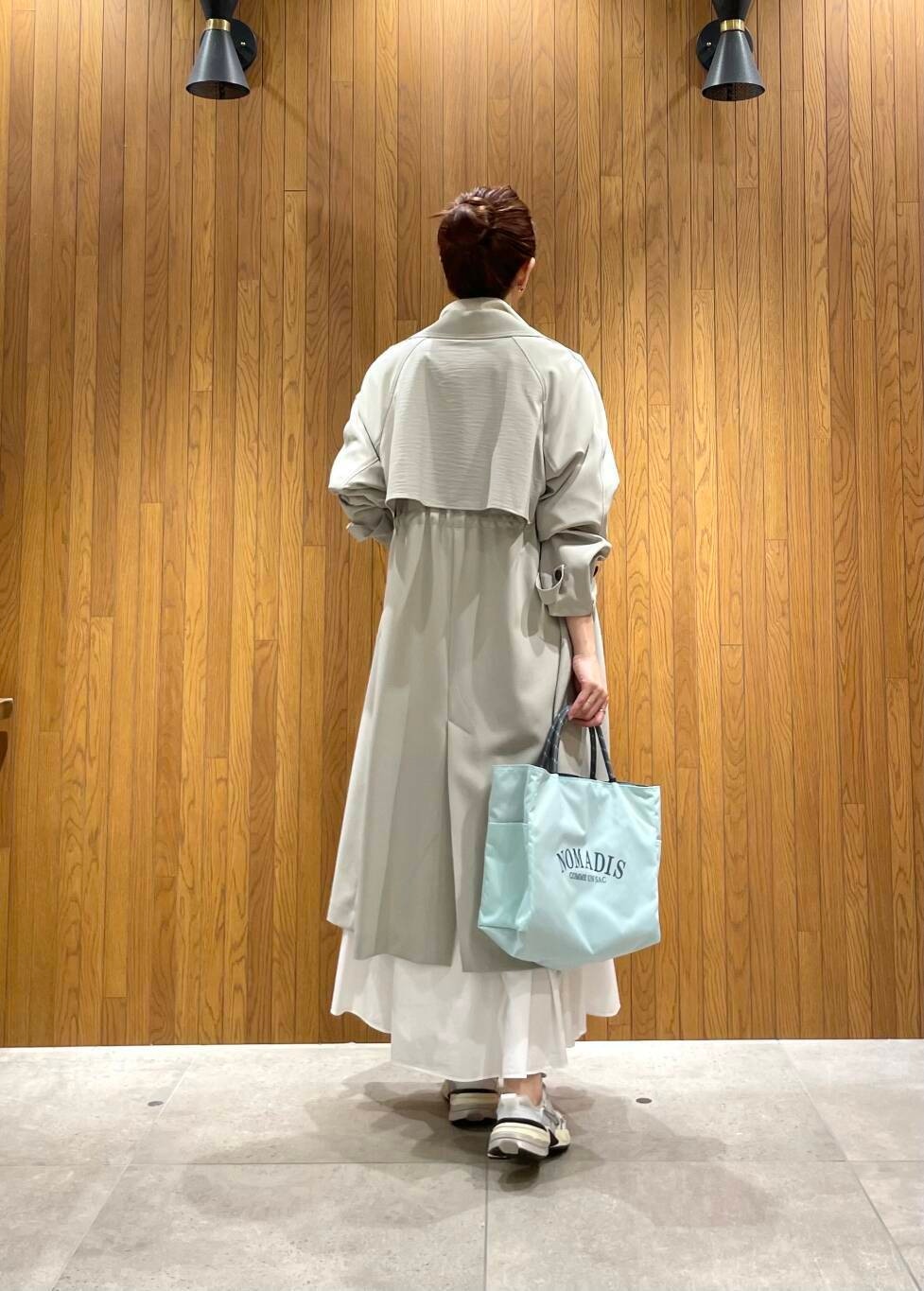 グリーン系のトレンチコート、その他のTシャツ/カットソー、ホワイト系のスカートを着用したレディースの春コーディネートの4枚目の写真