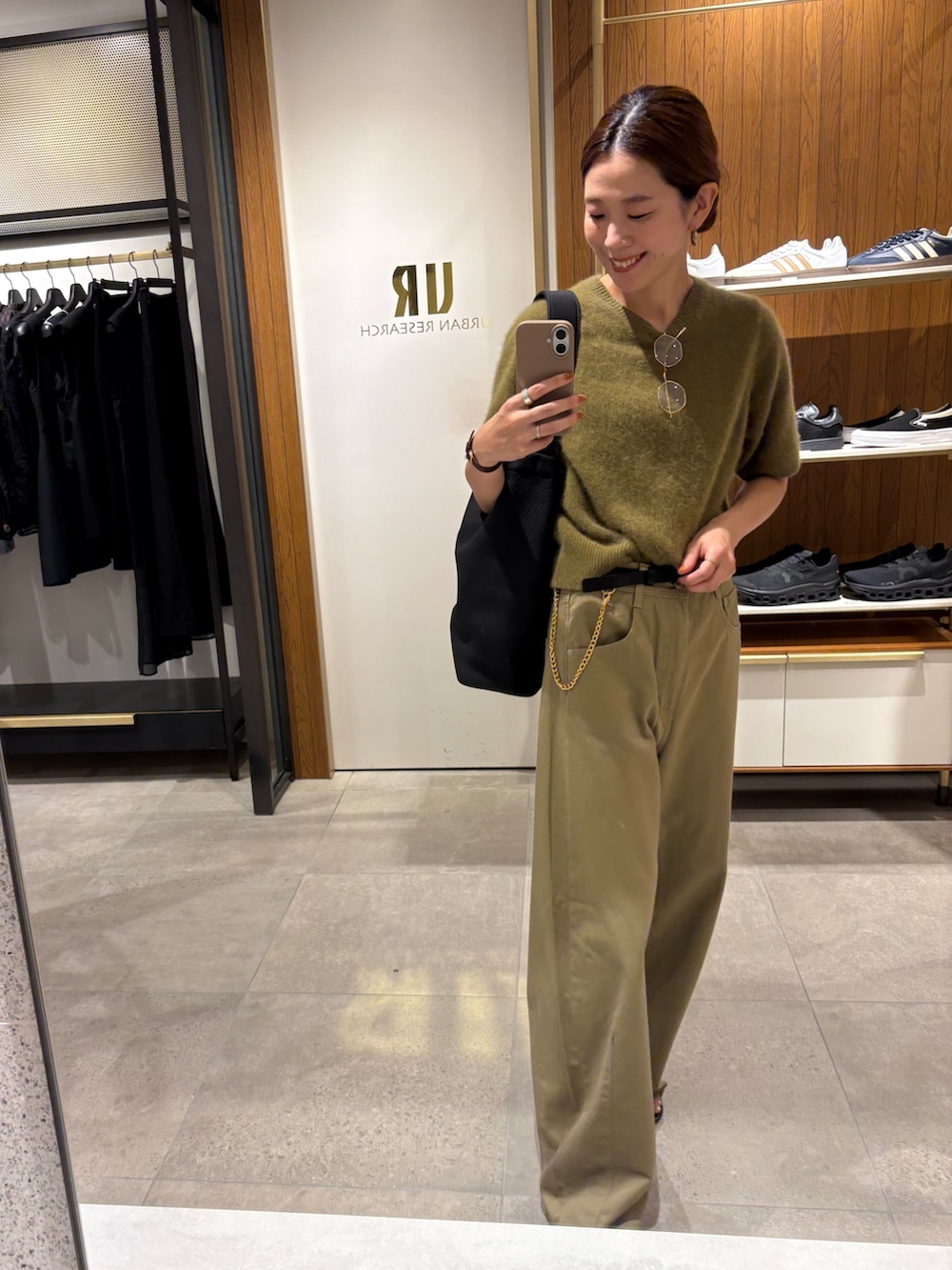 ブラック系のその他パンツ、グリーン系のニット/セーター、ブラック系のトートバッグを着用したレディースの夏コーディネートの2枚目の写真