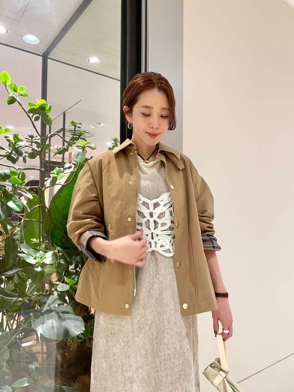 イエロー系のTシャツ/カットソー、ベージュ系のワンピース、ホワイト系のニット/セーターを着用したレディースの冬コーディネートの7枚目の写真