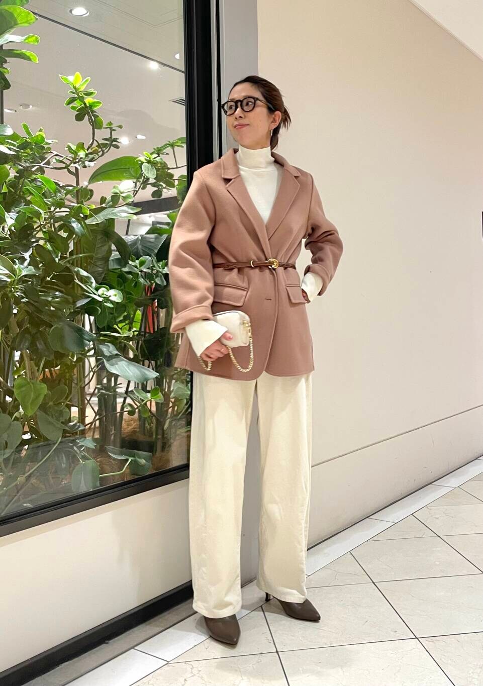 ホワイト系のニット/セーター、ベージュ系のその他アウター、ブラウン系のブーツを着用したレディースの秋コーディネートの4枚目の写真