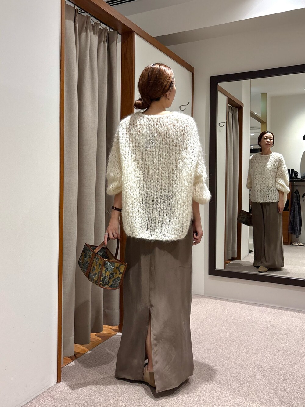 ホワイト系のニット/セーター、ブラック系のローファー、グリーン系のスカートを着用したレディースの秋コーディネートの3枚目の写真