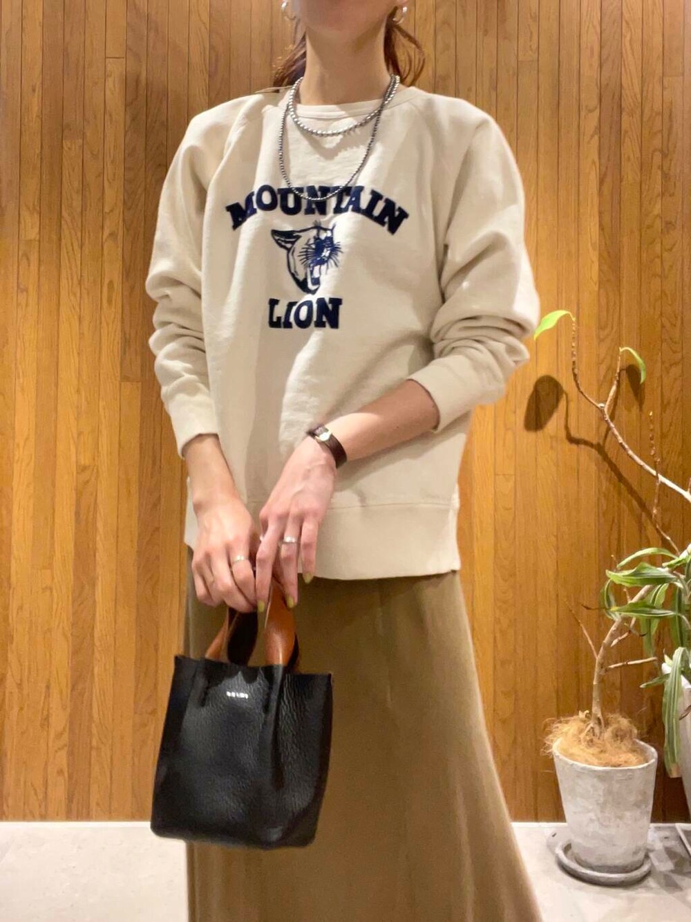 イエロー系のスカート、ベージュ系のスウェットを着用したレディースの冬コーディネートの4枚目の写真