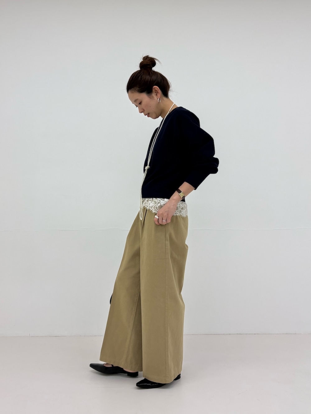 ブラック系のパンプス、ブルー系のニット/セーター、ベージュ系のその他パンツを着用したレディースの冬コーディネートの5枚目の写真