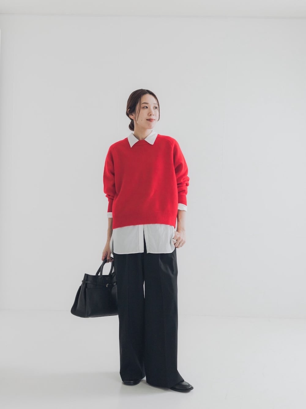 レッド系のニット/セーター、グレー系のその他パンツ、ブルー系のシャツ/ブラウスを着用したレディースの秋コーディネートの2枚目の写真